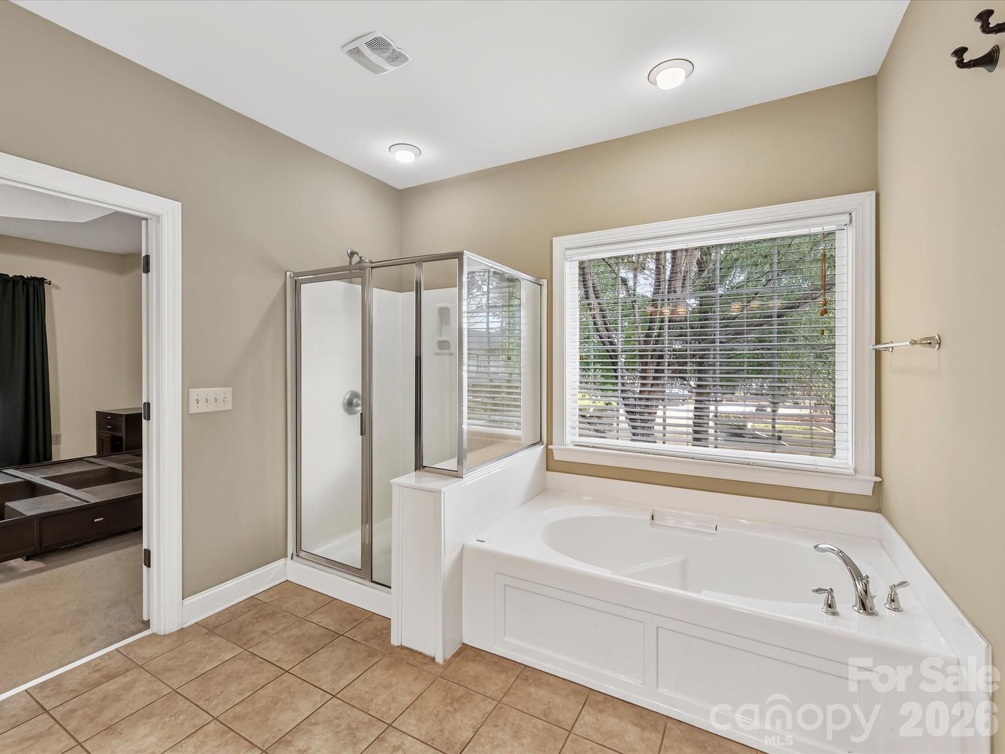 Spacious primary bath features a long dual-sink vanity, generous counter space, and convenient access to the walk-in closet - 11203 Warfield Avenue, Huntersville
