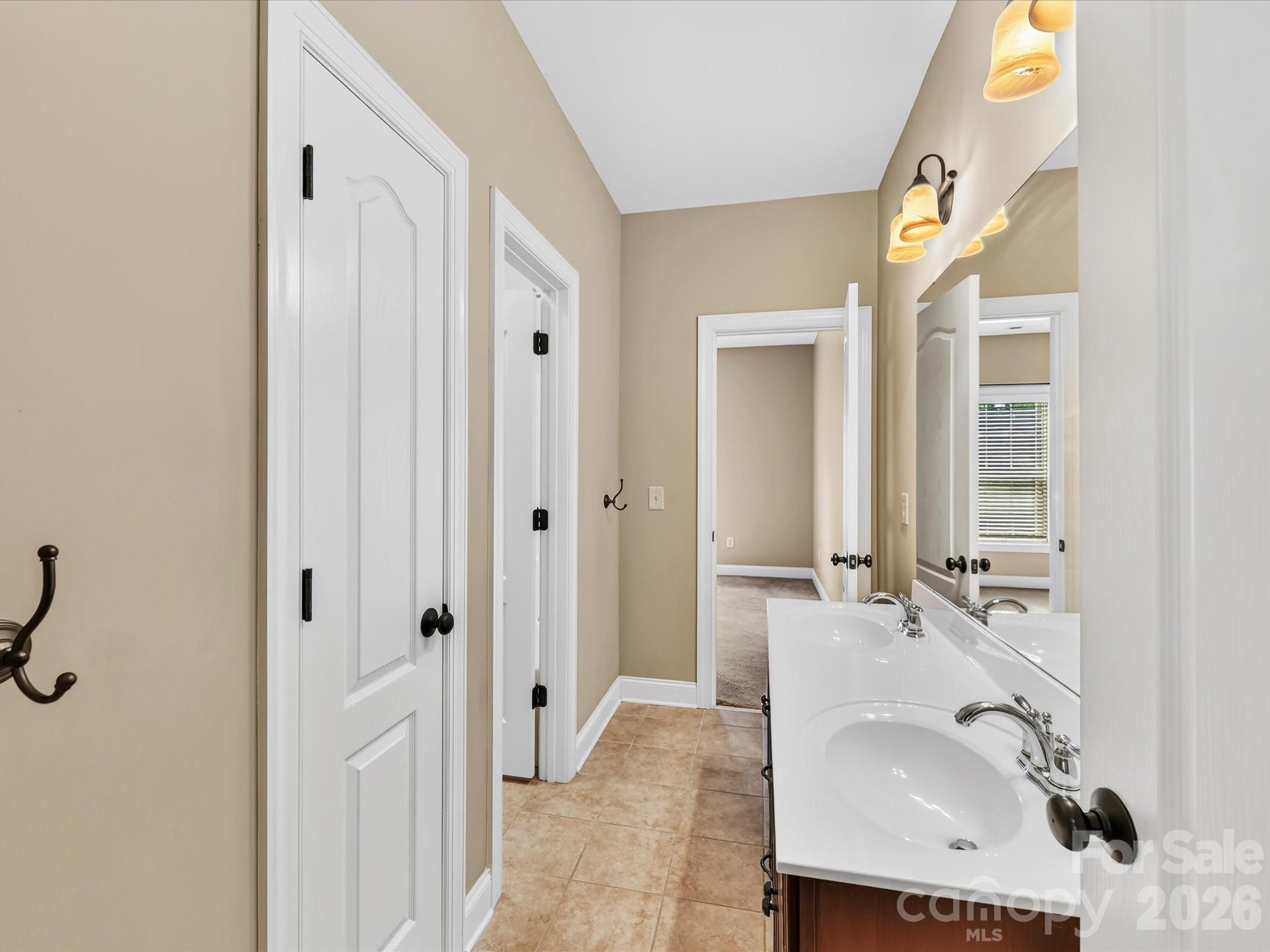 Convenient Jack-and-Jill bathroom features a dual-sink vanity and connects the secondary bedrooms. - 11203 Warfield Avenue, Huntersville