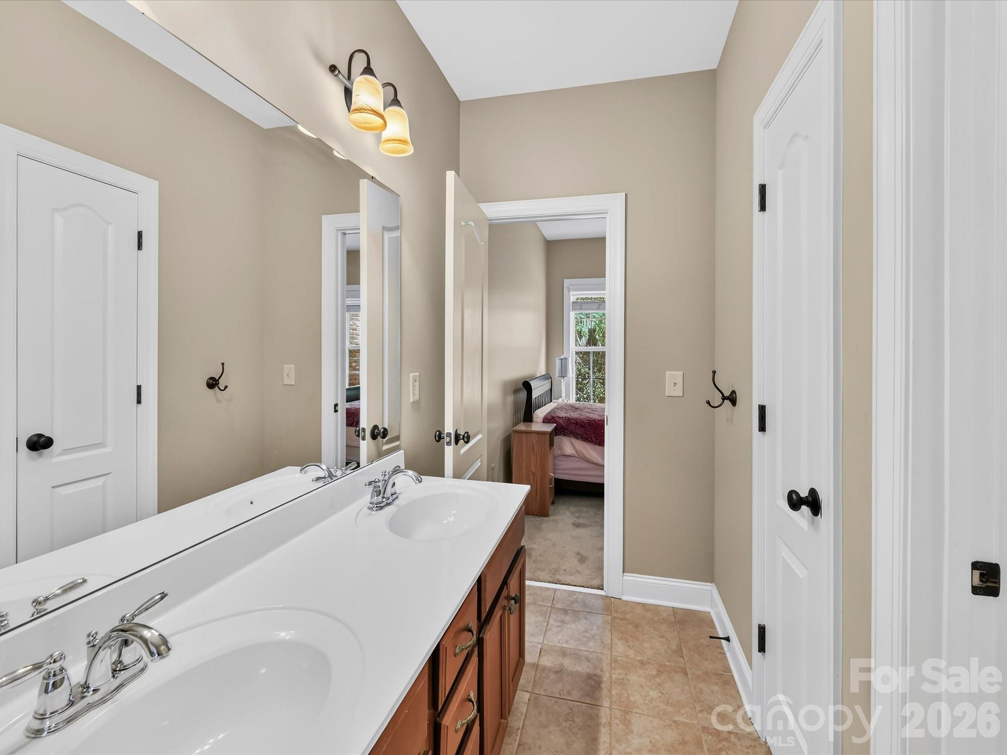 Convenient Jack-and-Jill bathroom features a dual-sink vanity and connects the secondary bedrooms. - 11203 Warfield Avenue, Huntersville