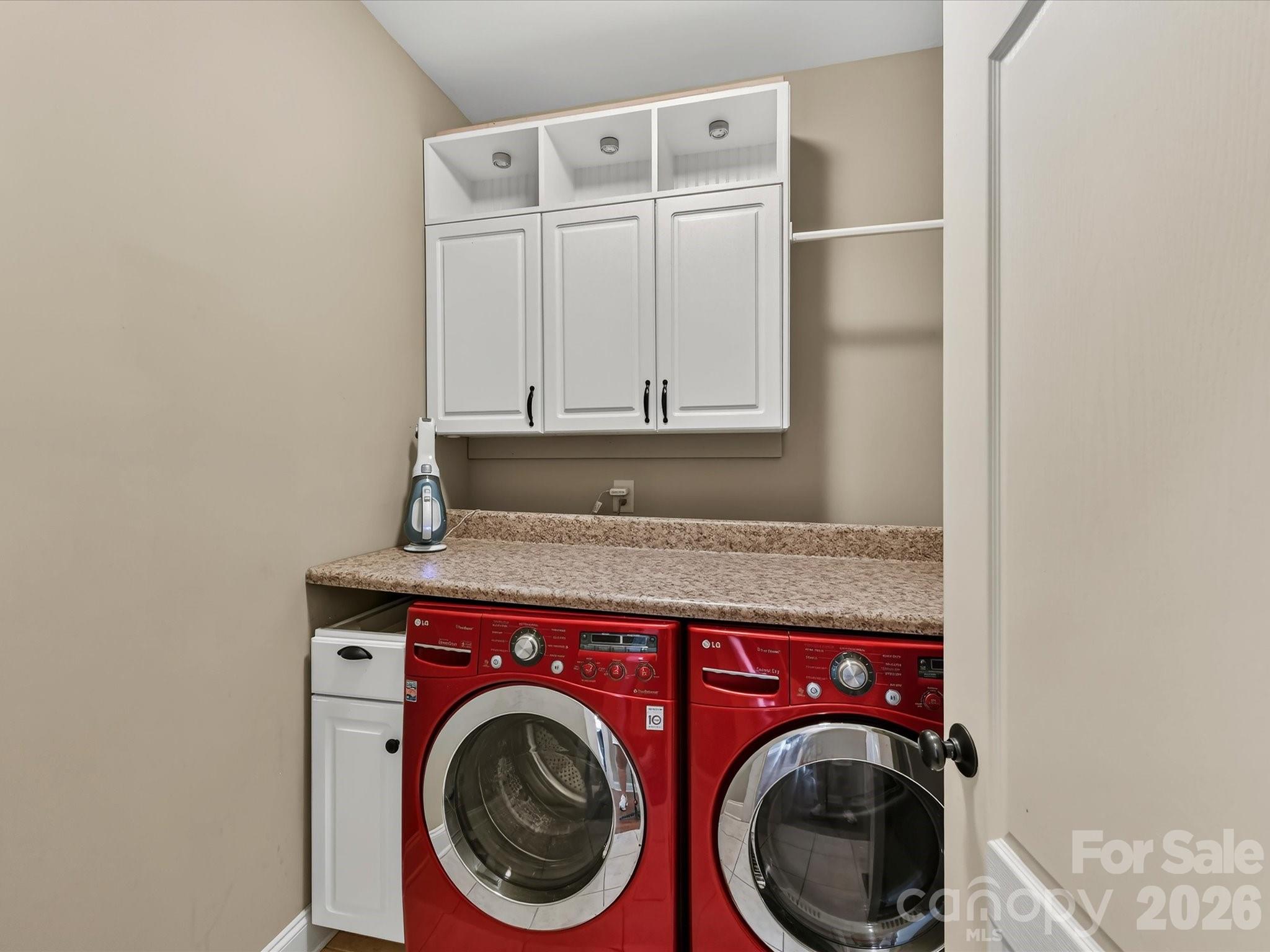 Dedicated laundry room features built-in cabinetry, countertop workspace, and additional storage. - 11203 Warfield Avenue, Huntersville