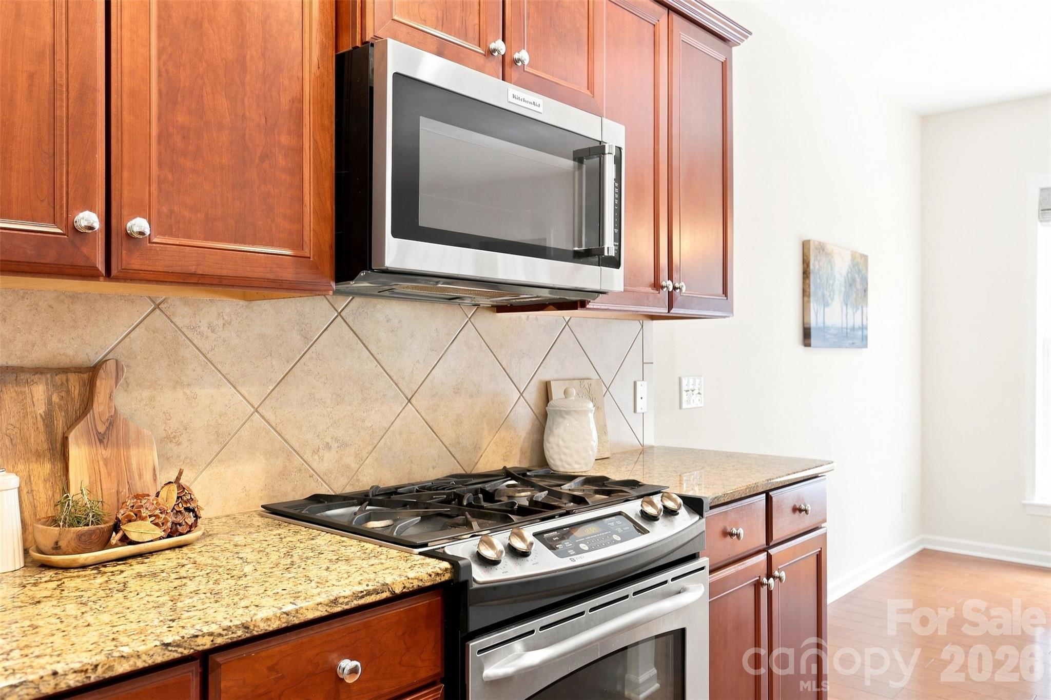 Five-burner gas range with an overhead microwave offers a convenient setup for everyday meals and entertaining - 10345 Scotland Avenue, Indian Land