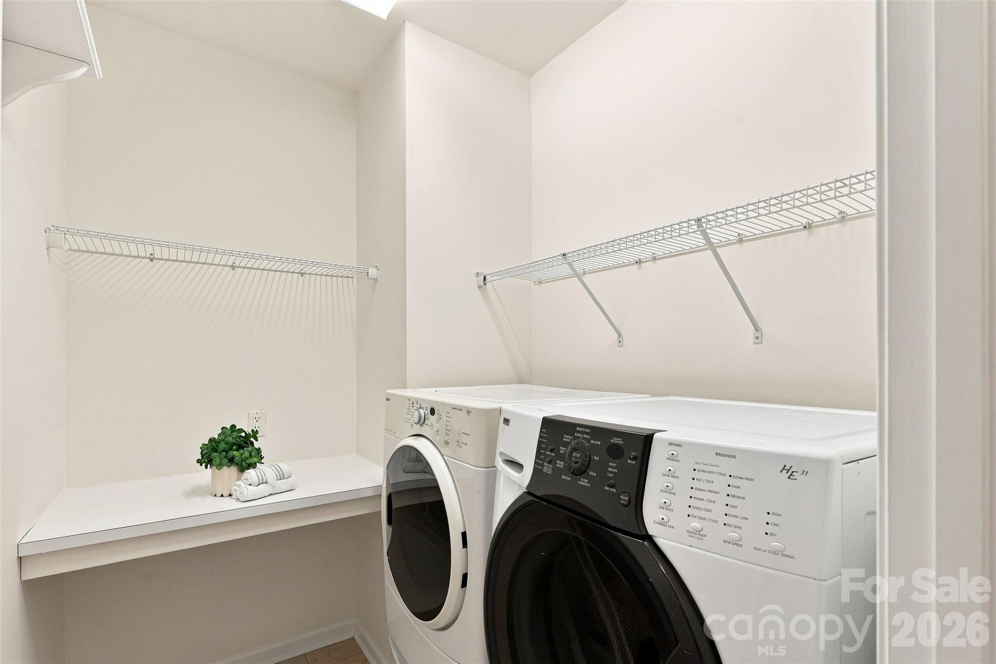 Convenient main-level laundry room includes built-in shelving and hanging space to keep everyday essentials neatly organized - 10345 Scotland Avenue, Indian Land