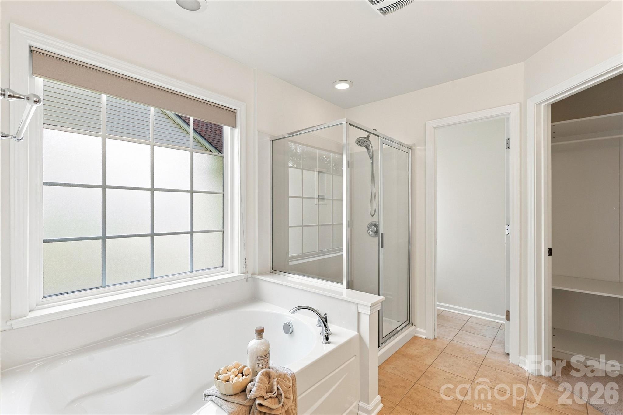 Relax in the garden tub or enjoy the convenience of a separate glass-enclosed shower, with a large window bringing natural light into the space - 10345 Scotland Avenue, Indian Land
