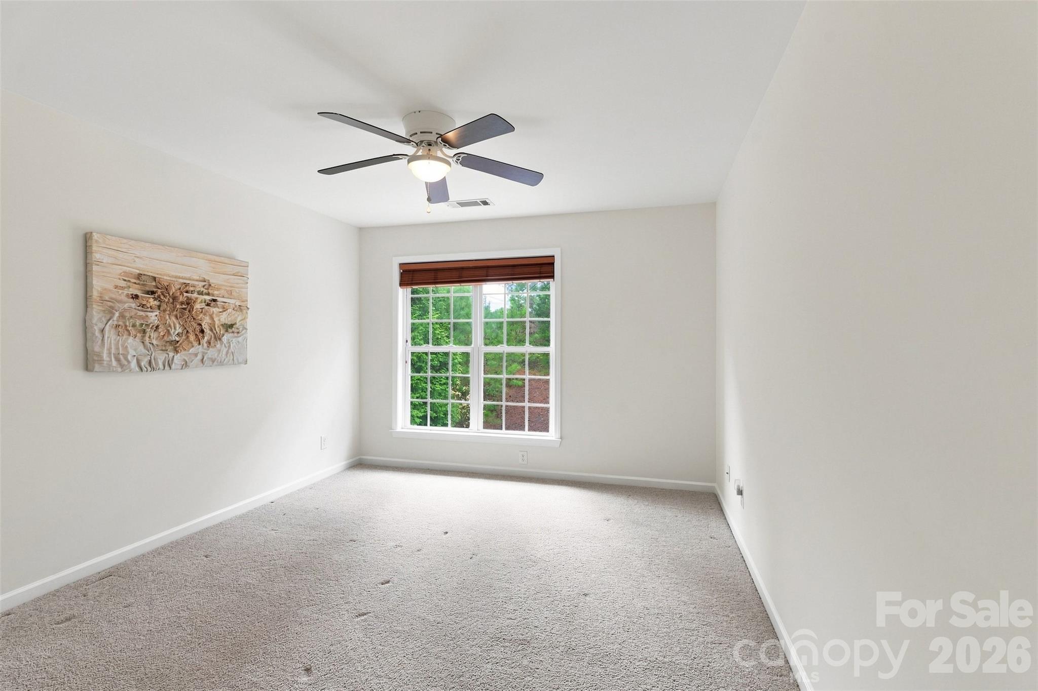 Rear-facing secondary bedroom offers a comfortable retreat with a large window framing peaceful backyard views - 10345 Scotland Avenue, Indian Land