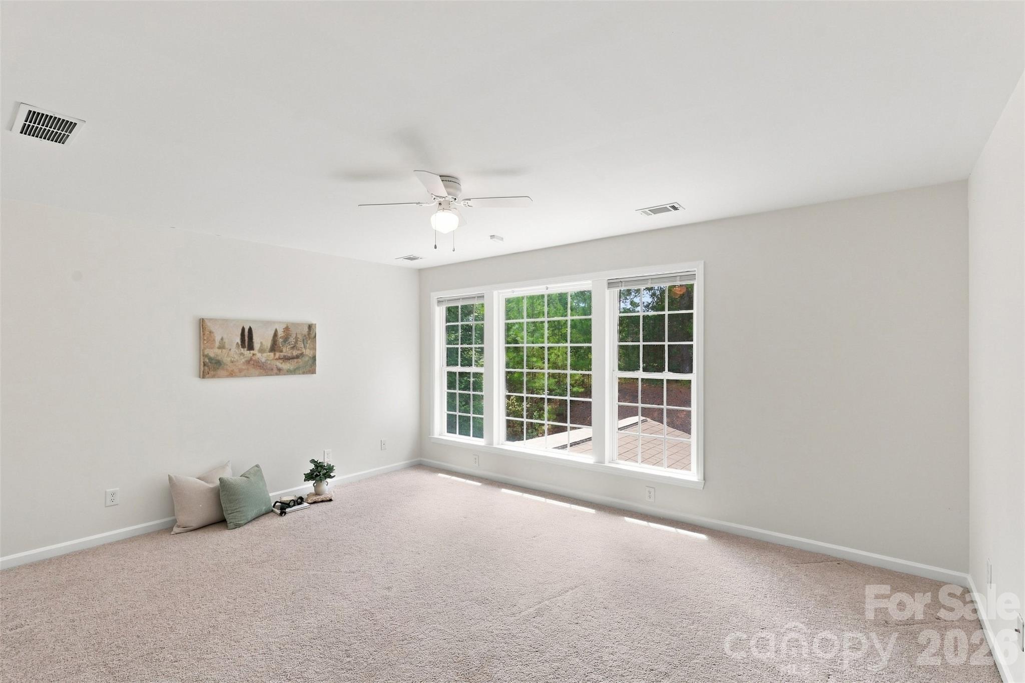 Expansive bonus room offers exceptional flexibility for a media room, playroom, home gym, or second living area, with oversized windows overlooking the wooded backdrop - 10345 Scotland Avenue, Indian Land