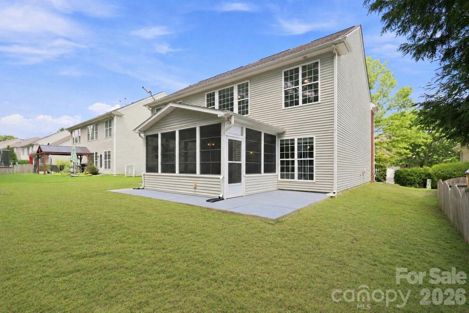 Rear exterior view highlights the home’s two-story design, four-seasons room addition, and backyard with room for outdoor activities - 10345 Scotland Avenue, Indian Land