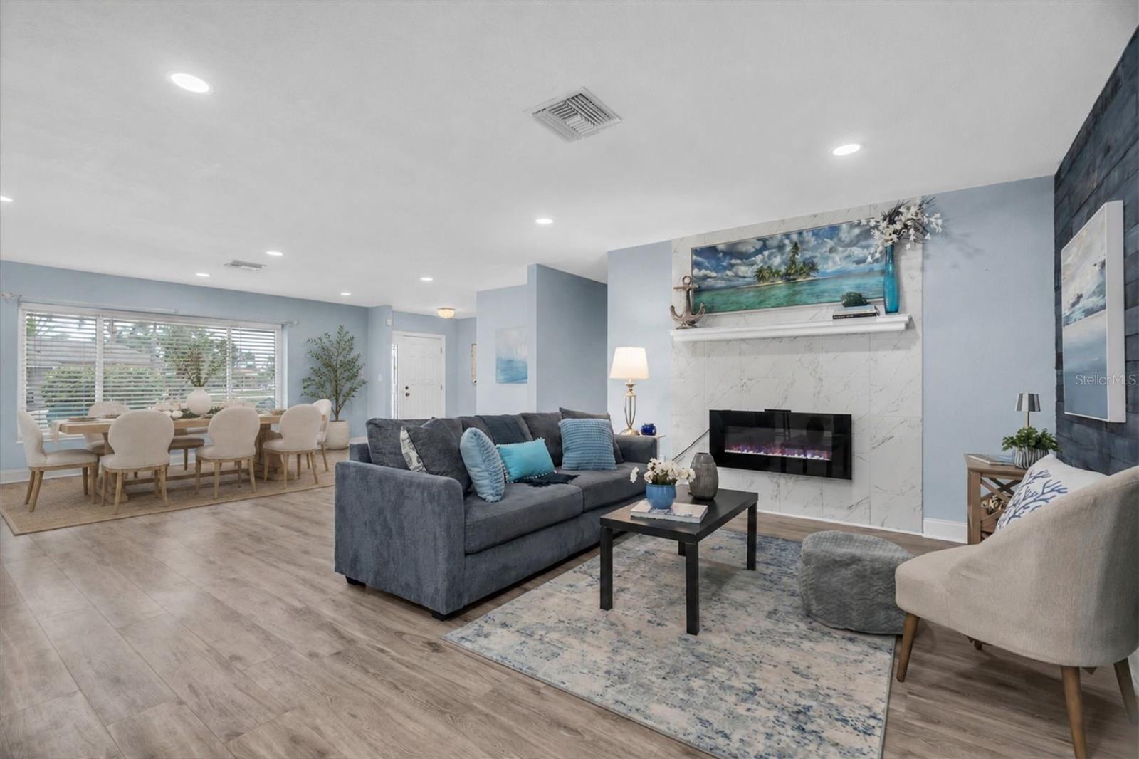 Open living and dining areas feature luxury vinyl plank flooring and a light coastal-inspired design. - 7891 4TH AVE S, ST PETERSBURG