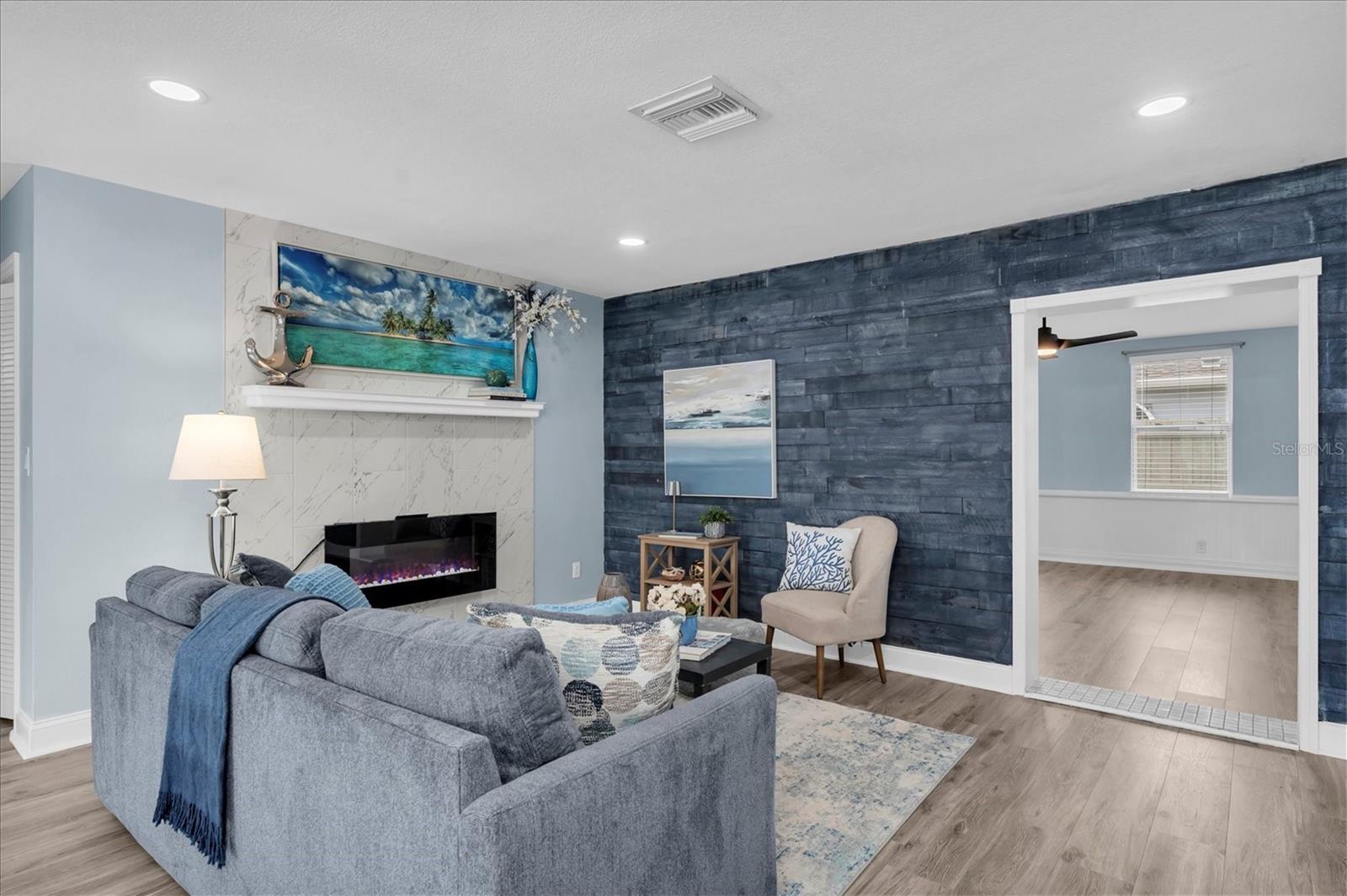 Blue shiplap accent wall brings coastal character to the main living space. - 7891 4TH AVE S, ST PETERSBURG