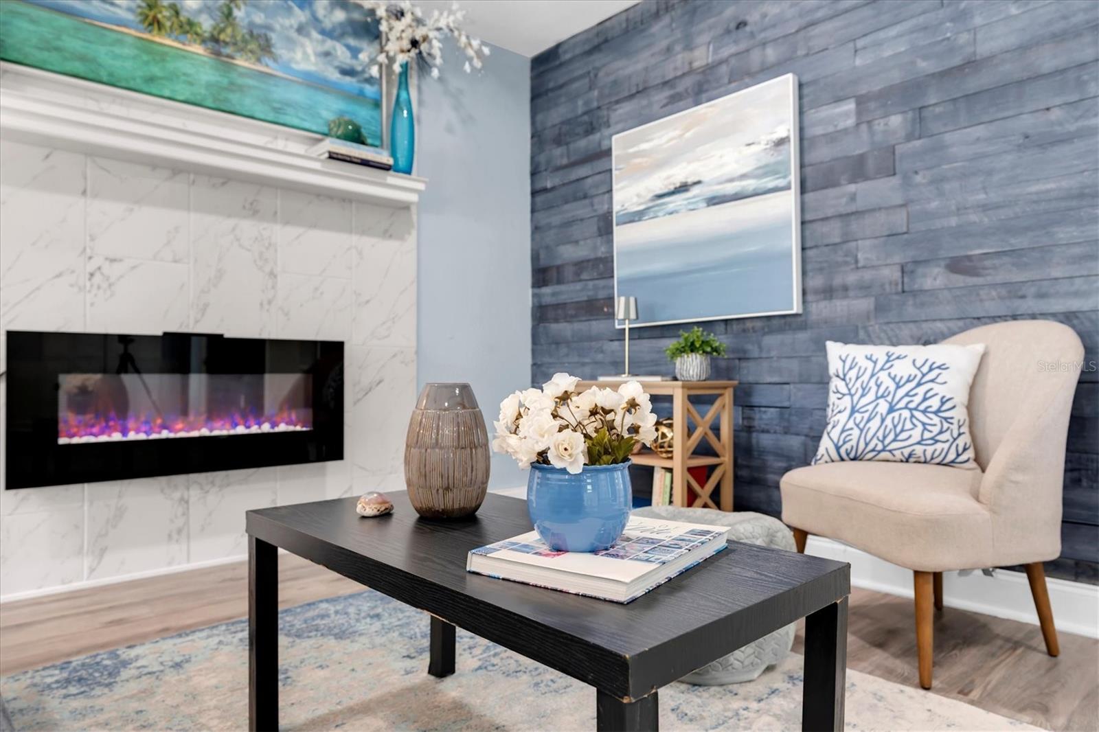 Marble-surround fireplace creates a stylish focal point for the living area. - 7891 4TH AVE S, ST PETERSBURG