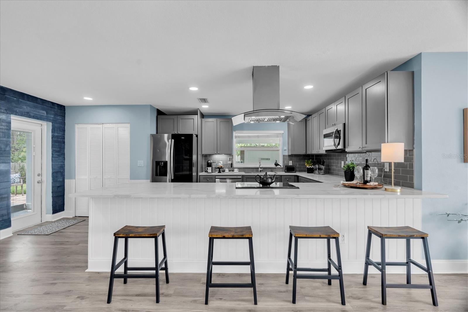 Large quartz peninsula provides additional prep space and casual seating while keeping the kitchen open to the living areas. - 7891 4TH AVE S, ST PETERSBURG