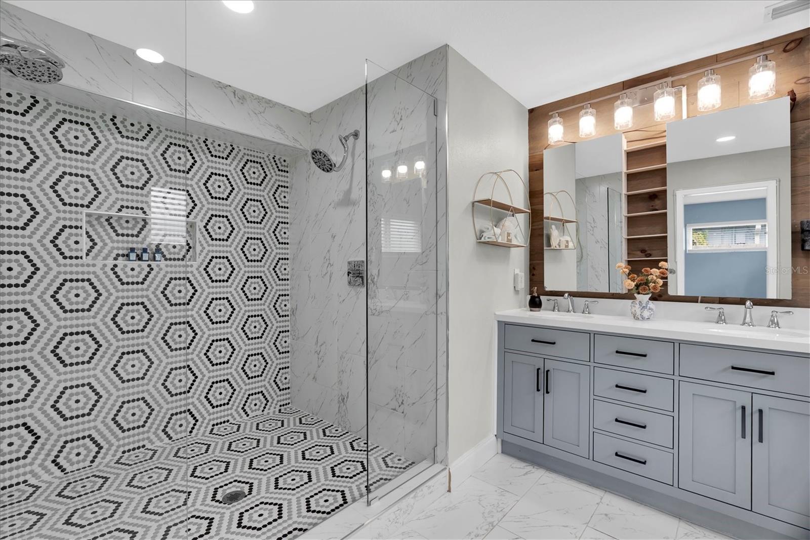Spa-inspired primary bath features an oversized doorless walk-in shower with designer tile and dual shower heads. - 7891 4TH AVE S, ST PETERSBURG