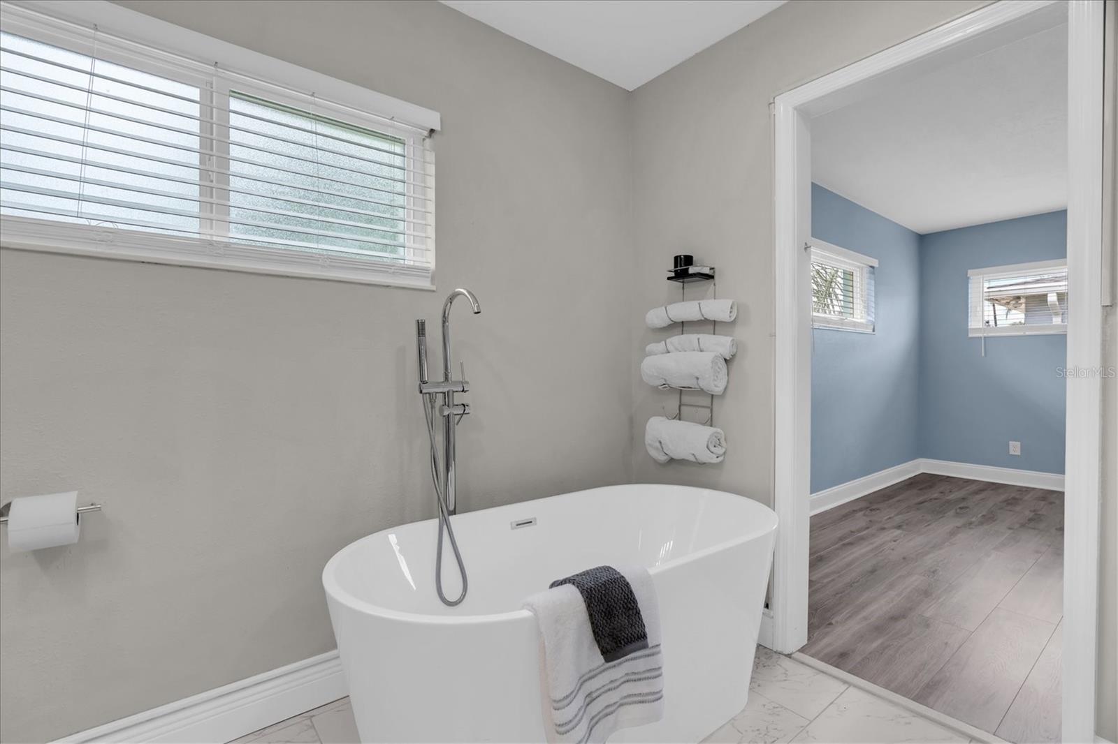 Freestanding clawfoot soaking tub and black iron fixtures complete the primary bath's modern coastal look. - 7891 4TH AVE S, ST PETERSBURG