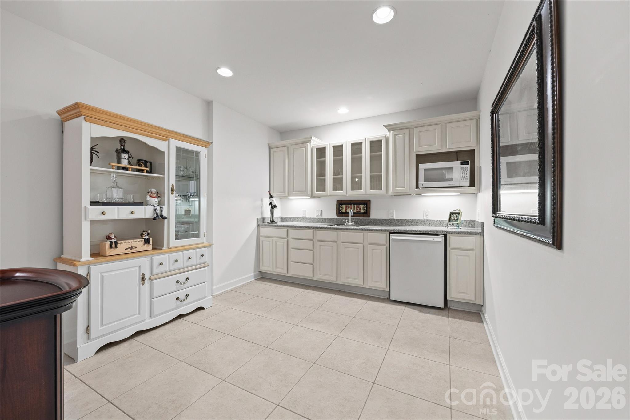 Kitchenette with sink, microwave, mini fridge and lots of cabinets for displaying bar ware. - 771 Cherry Hills Place, Rock Hill
