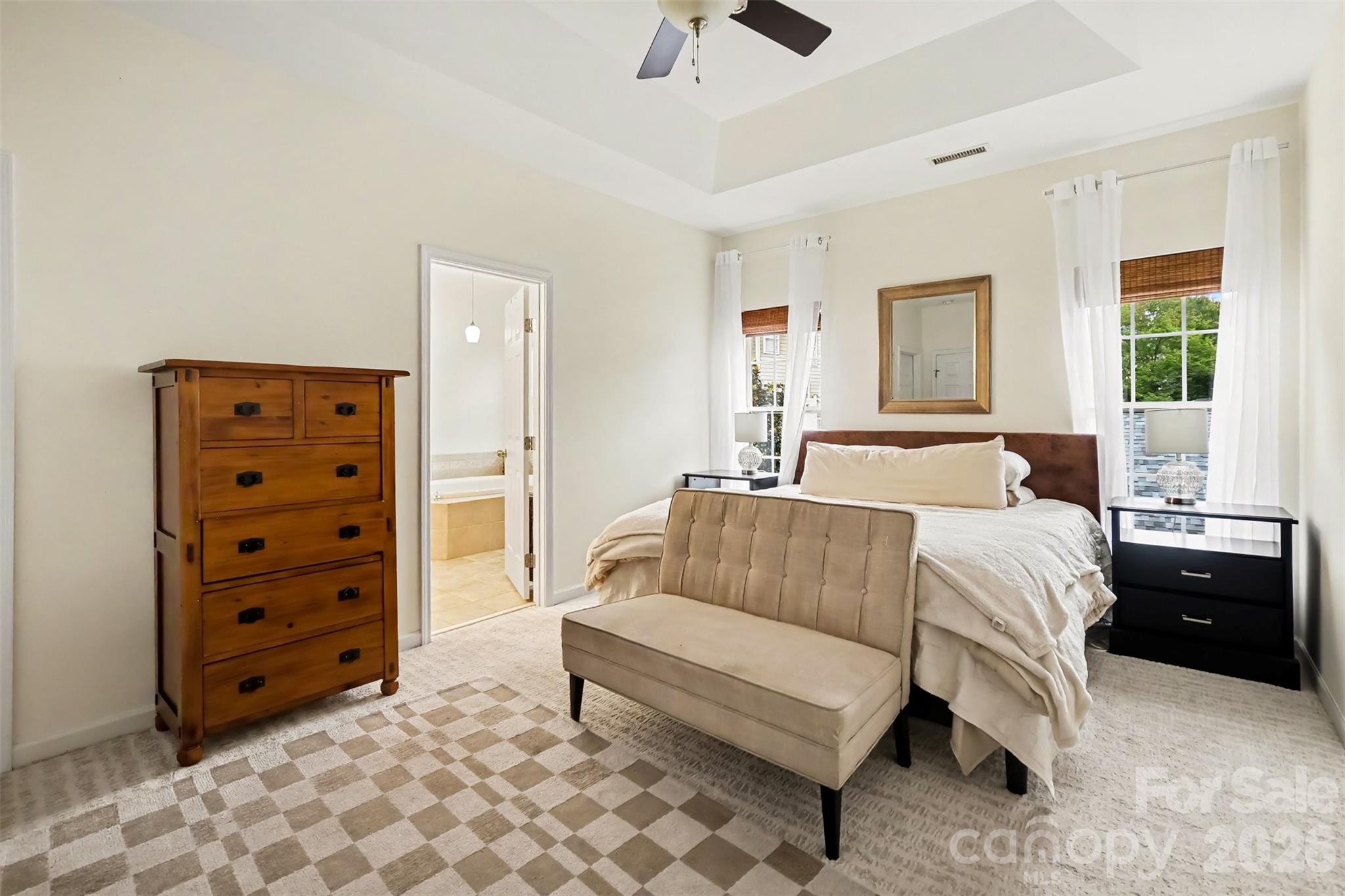 Spacious primary bedroom has tray ceilings and loads of natural light Carpet just over a year old - 438 Magnolia Street, Davidson