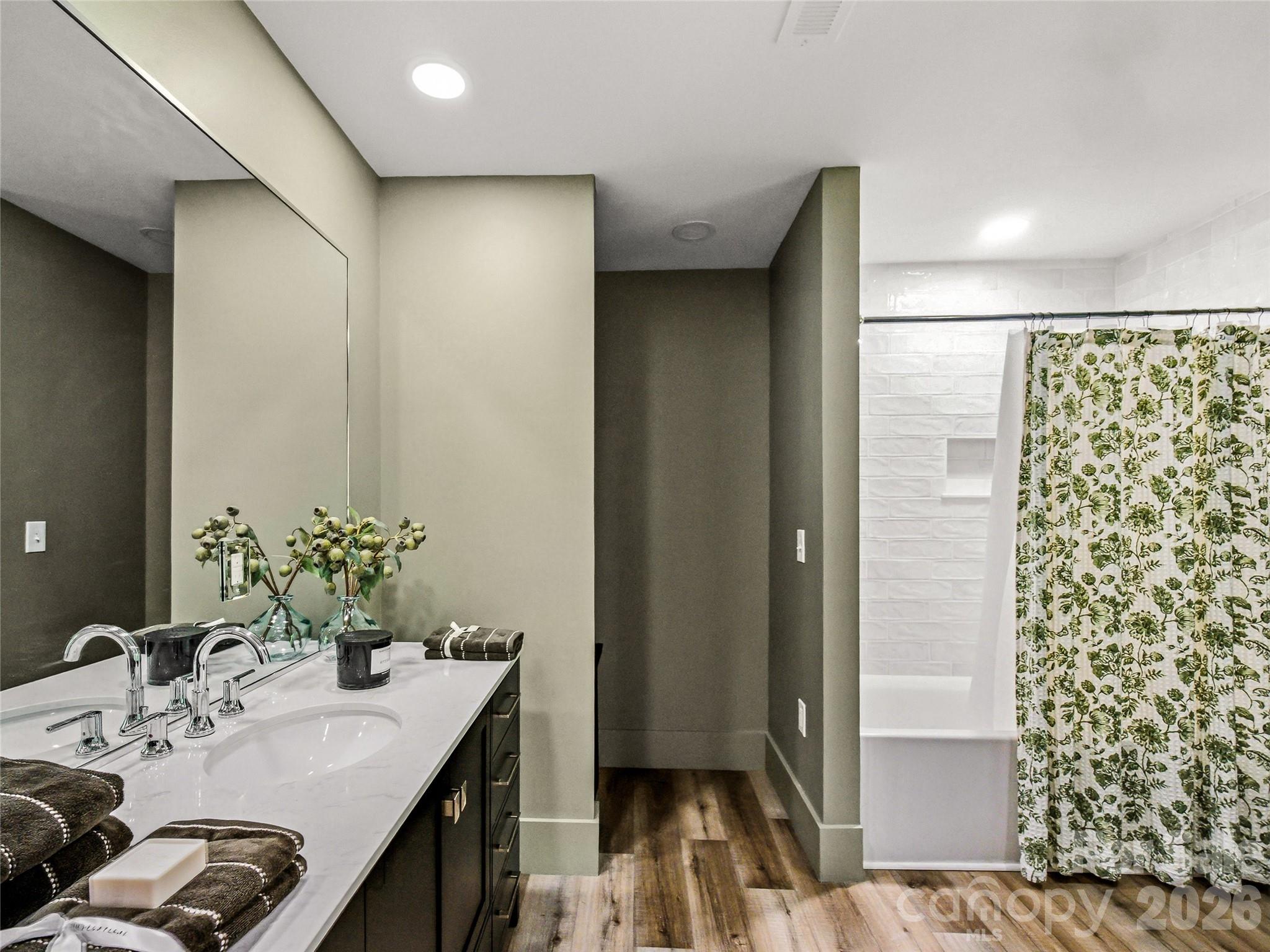 Updated first-floor bathroom featuring a tub/shower combination and a conveniently located laundry nook. - 81 Summer Trees Lane, Burnsville