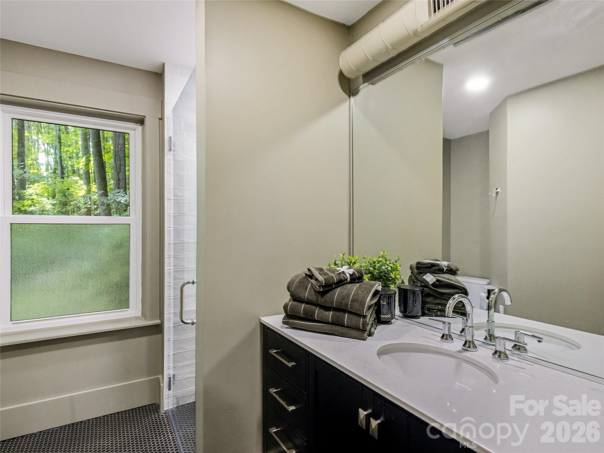 Beautifully updated en-suite bathroom featuring a tiled shower with seamless glass doors and stylish modern finishes. - 81 Summer Trees Lane, Burnsville