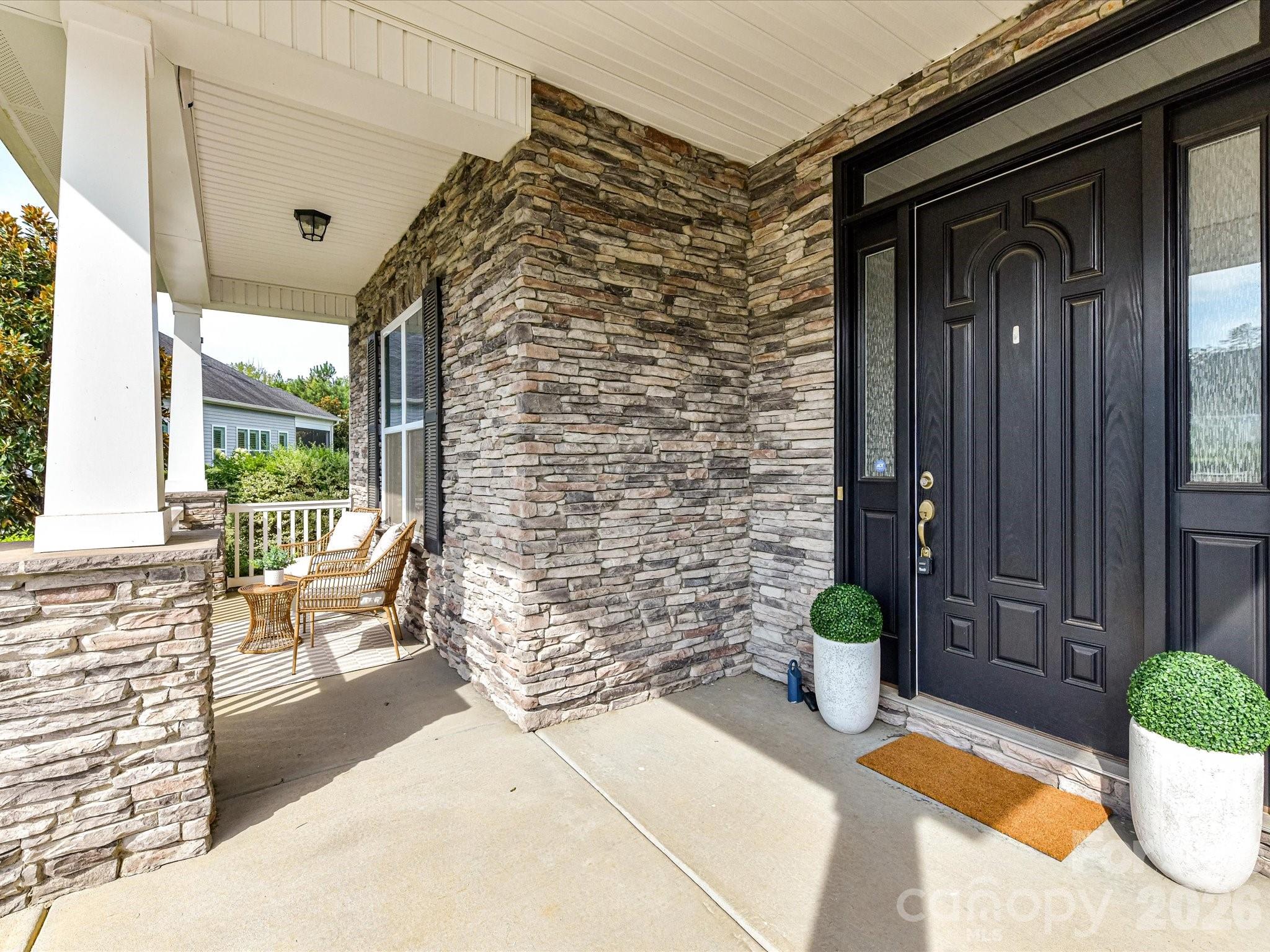 Welcoming covered front porch features handsome stone accents and plenty of space to relax and enjoy the outdoors. - 13003 Riley Grace Lane, Cornelius