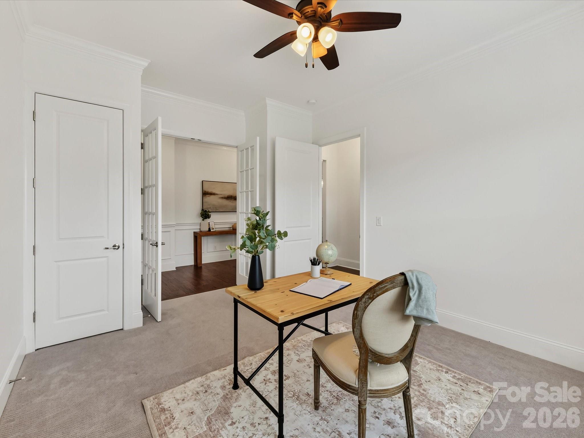 Versatile home office offers abundant natural light, crown molding, French doors, and ample space for a comfortable, private workspace. - 13003 Riley Grace Lane, Cornelius