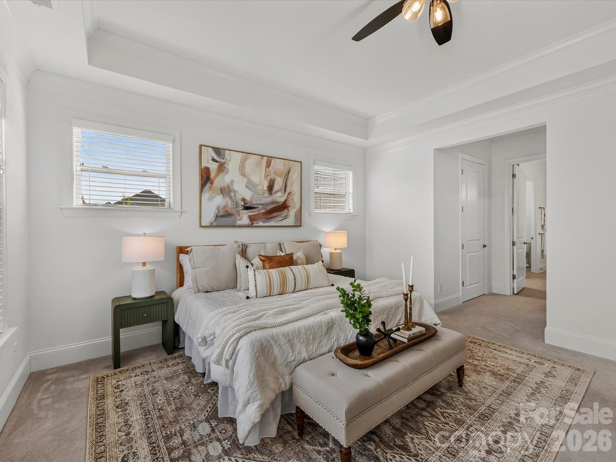 Spacious primary suite features a deep tray ceiling, abundant natural light, and a serene layout offering a comfortable private retreat. - 13003 Riley Grace Lane, Cornelius