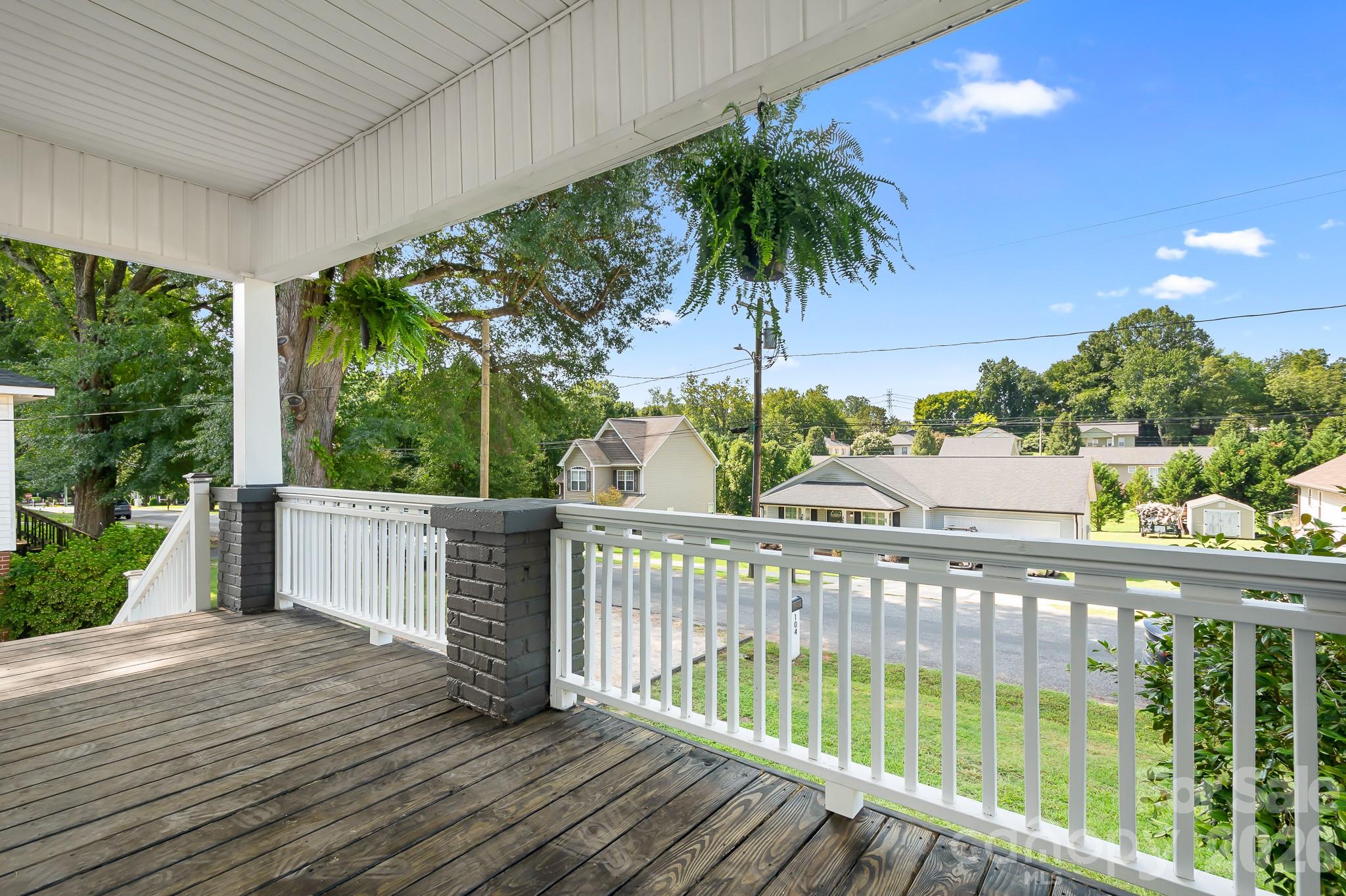 Welcoming covered front porch offering a relaxing spot to unwind and enjoy the surrounding views - 104 1st Avenue, China Grove