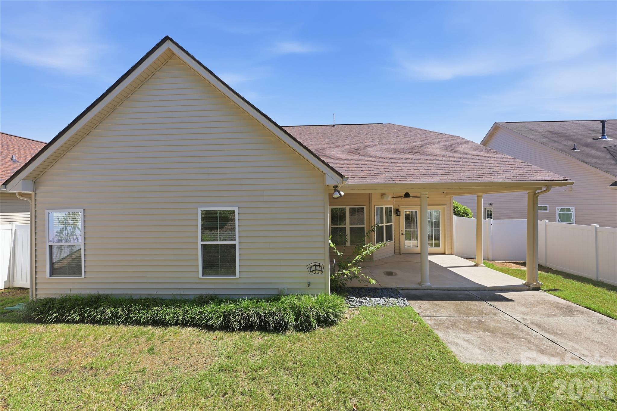 Rear of home showing the extended covered patio + extra uncovered patio space - 593 Harrison Drive NW, Concord