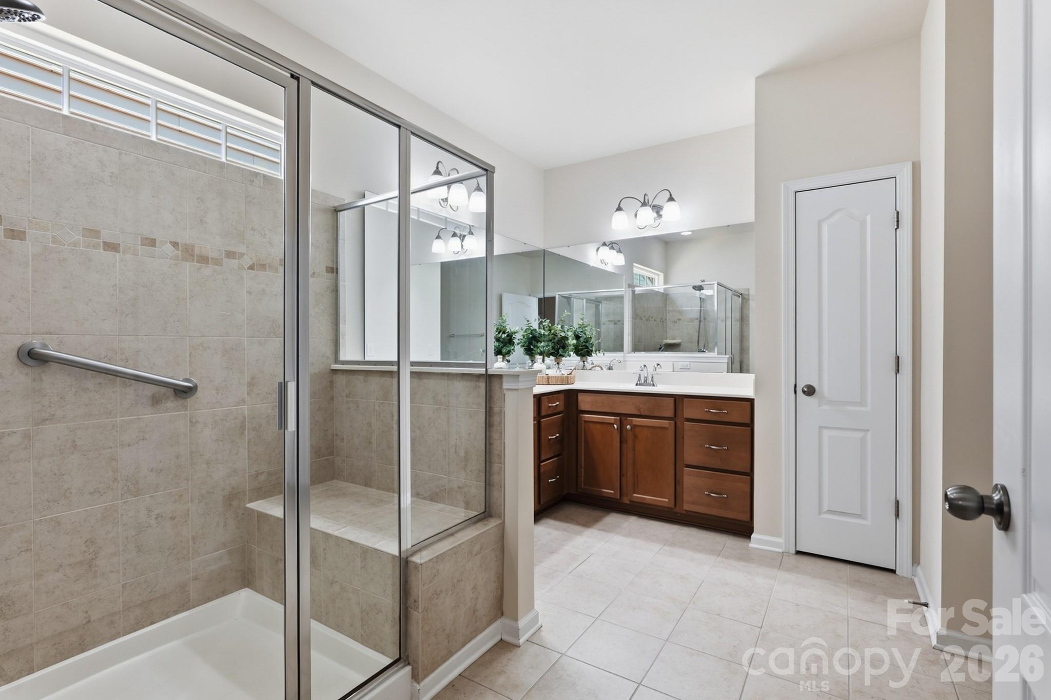 Primary ensuite bathroom with walk-in shower featuring grab bar and bench seat - 4043 Perth Road, Indian Land