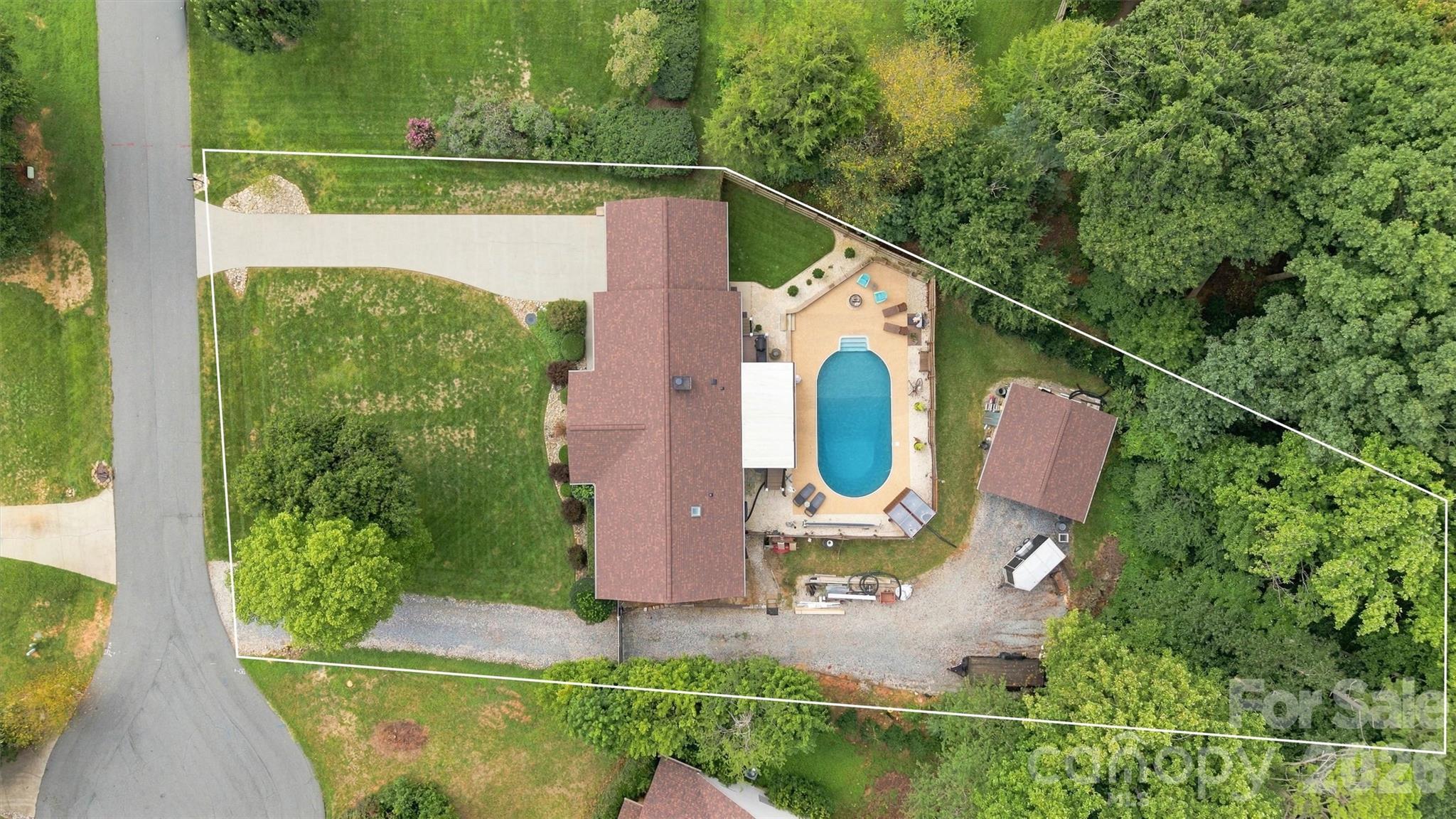 Detached 15'x24' garage/workshop featuring a 9'x8' garage door with 8'x24' carport is hidden behind pool, accessible only through electric gate on right side of home. - 3867 Angie Drive, Denver