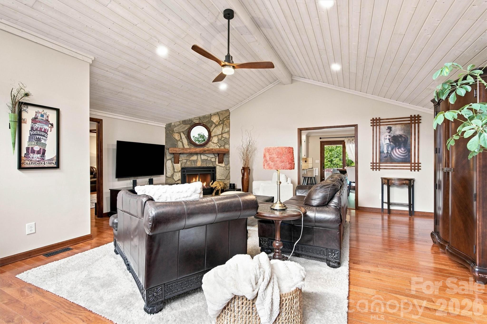 Stunning floor-to-ceiling stone fireplace featuring a handcrafted solid walnut mantel, serving as a sophisticated focal point for this expansive family room. - 3867 Angie Drive, Denver