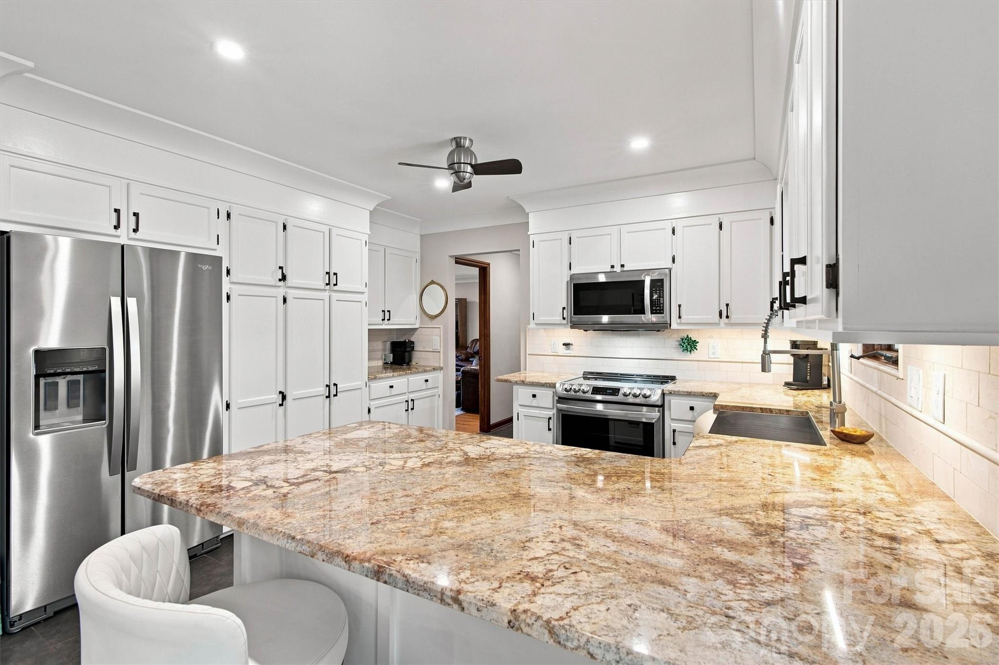 Gorgeous, updated kitchen featuring an eat-in breakfast bar that serves as the heart of the home. - 3867 Angie Drive, Denver