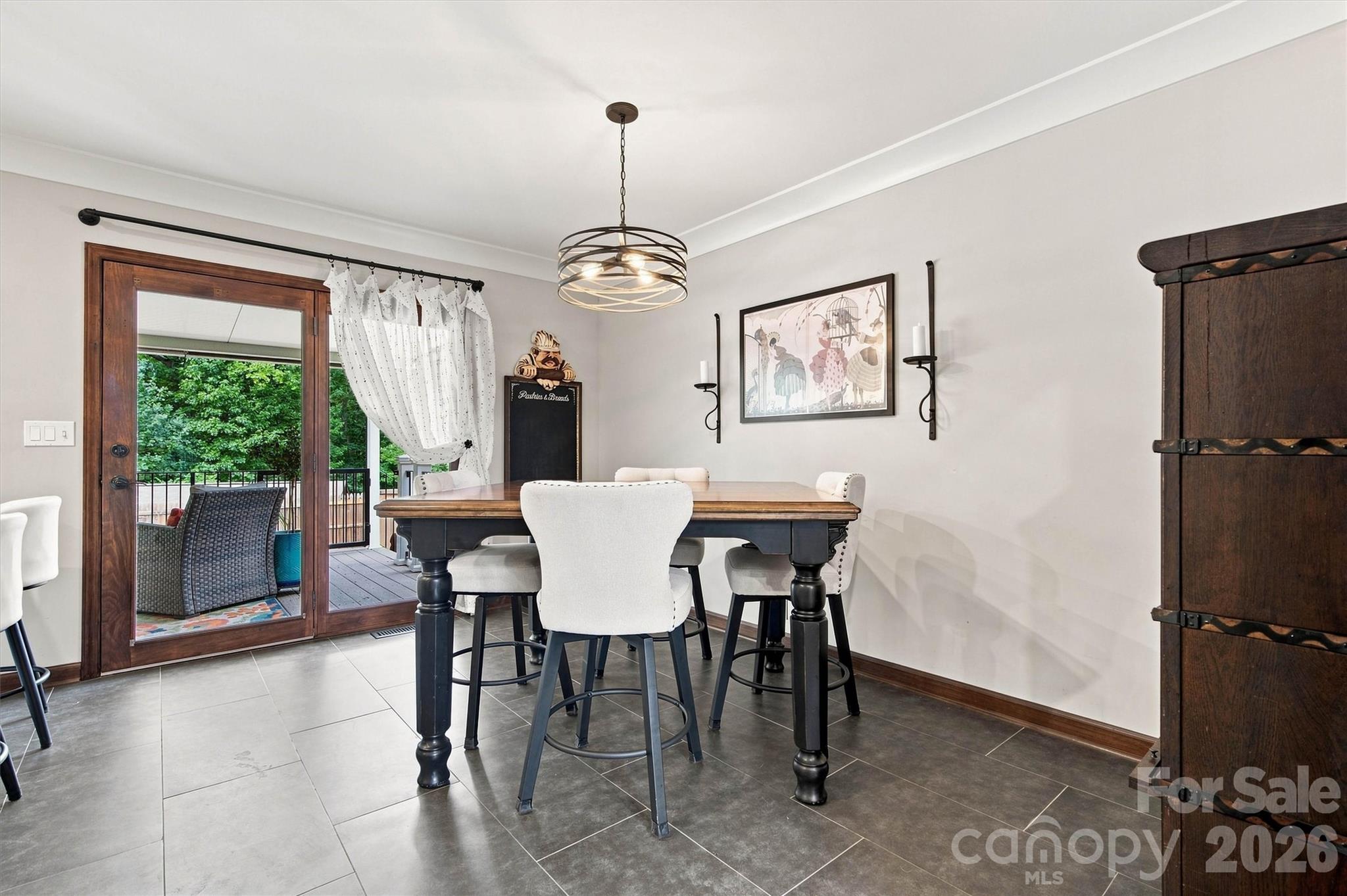 The dining area is conveniently located adjacent to the kitchen and features direct access to a screened porch overlooking the pool, making it an ideal space for entertaining and family gatherings. - 3867 Angie Drive, Denver