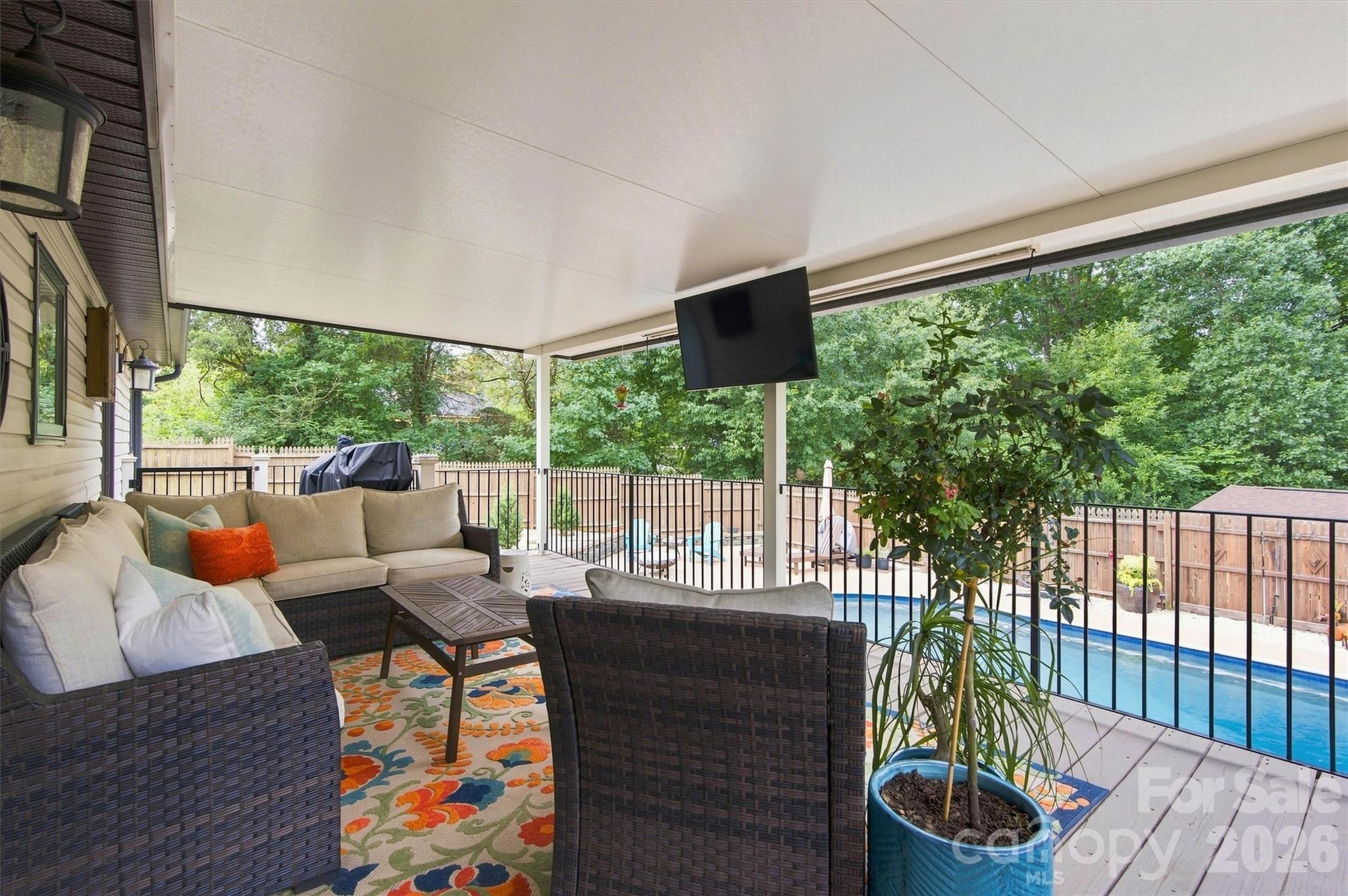 This is the place to be! Covered rear porch overlooking the amazing pool area. TV mount remains and sellers might be talked into leaving the TV as well! - 3867 Angie Drive, Denver