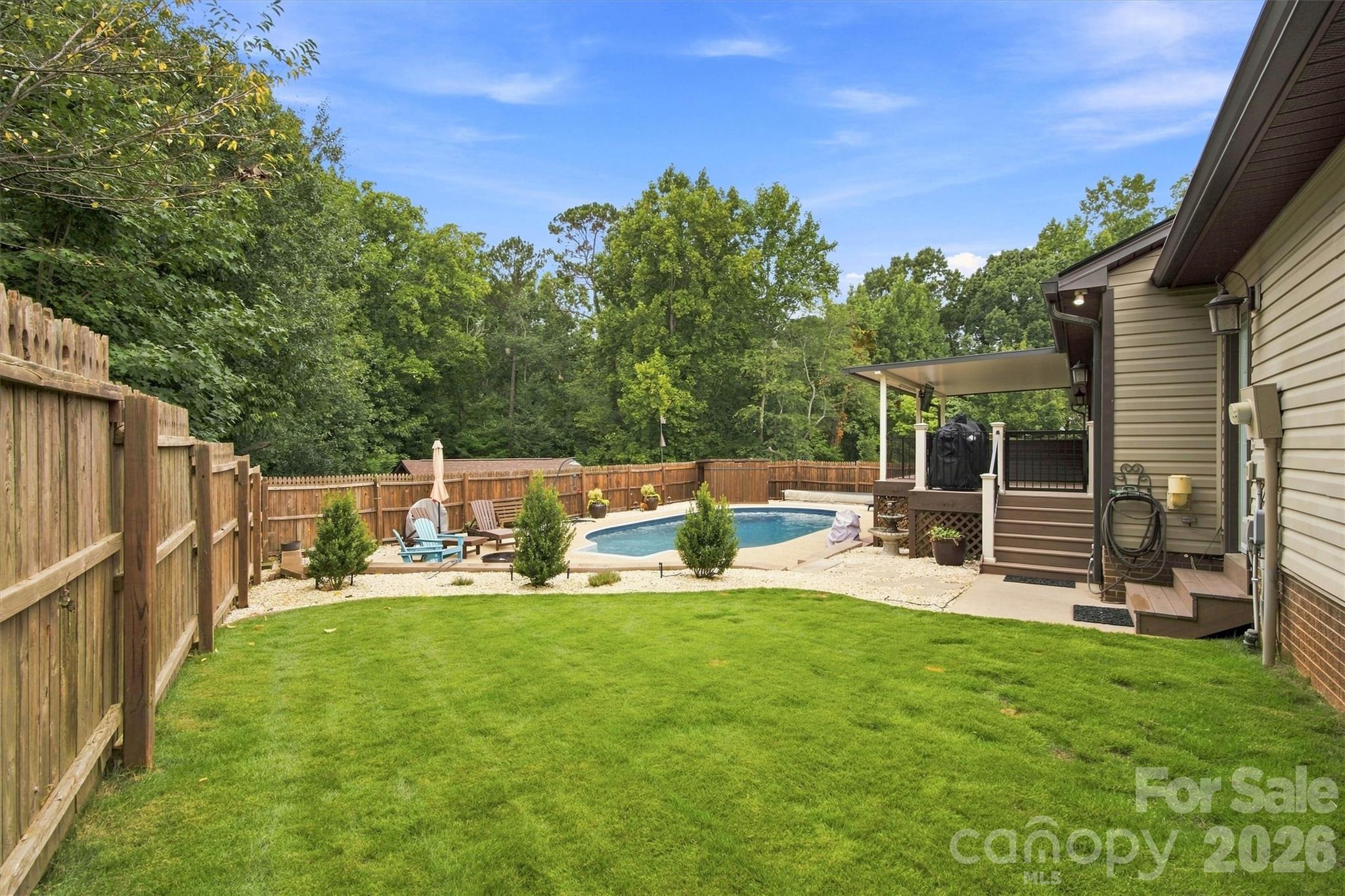 Lovely area for kids or pets to play adjacent to the pool and covered porch. Convenient rear entry to garage to the right. - 3867 Angie Drive, Denver