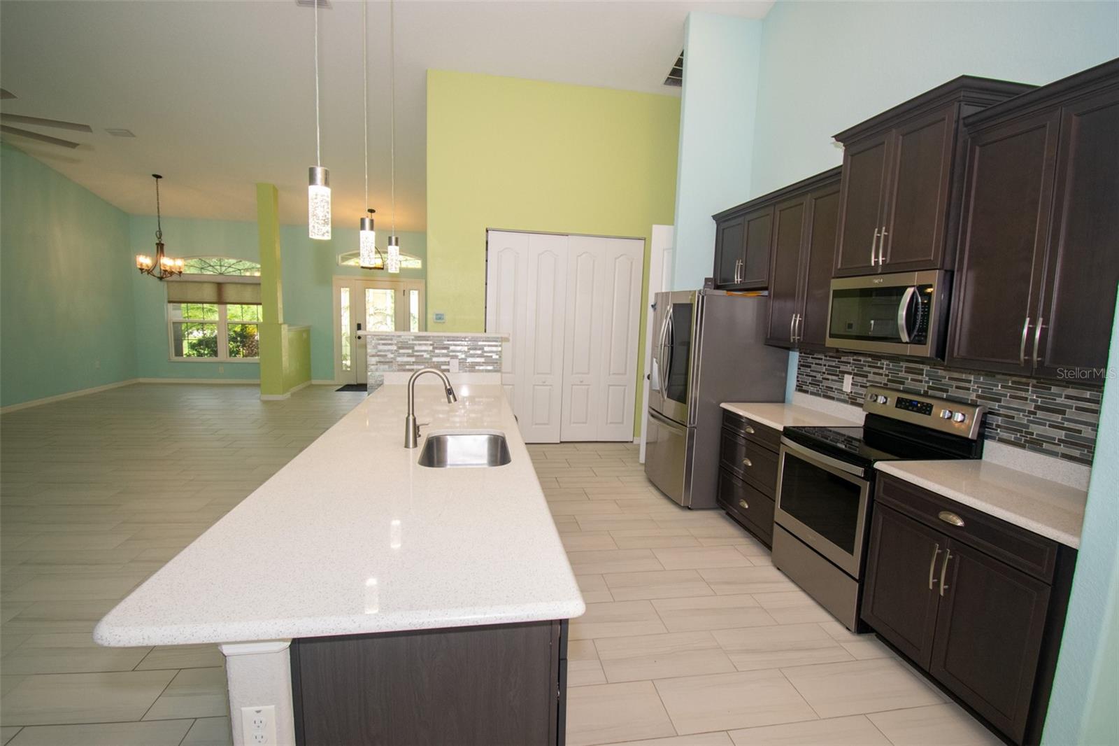 Spacious island kitchen featuring stainless steel appliances and a convenient walk-in pantry. - 225 BIRCHWOOD DR, PALM COAST
