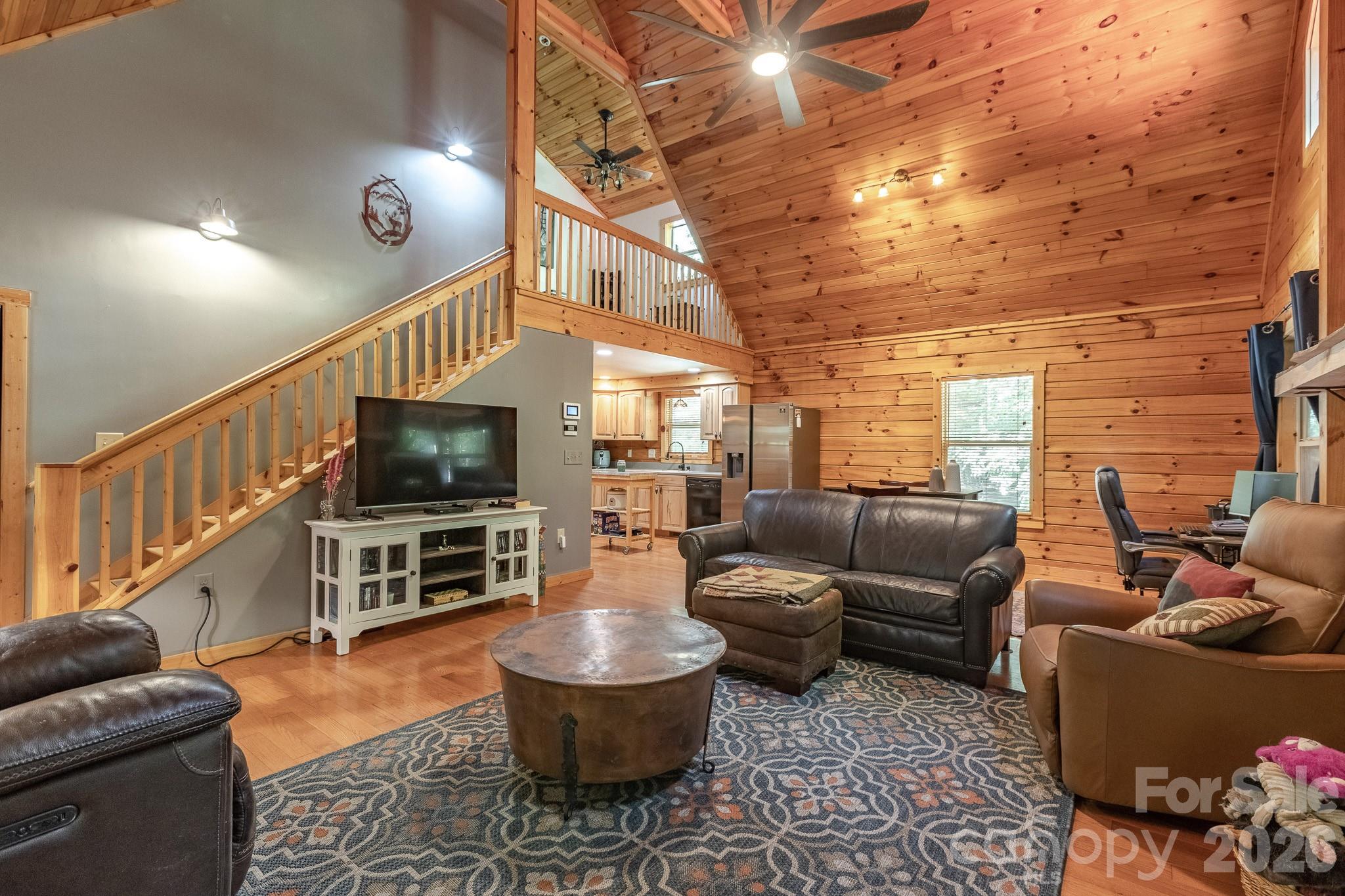 Living room looking into kitchen, and loft above. - 257 Adirondack Trail, Nebo