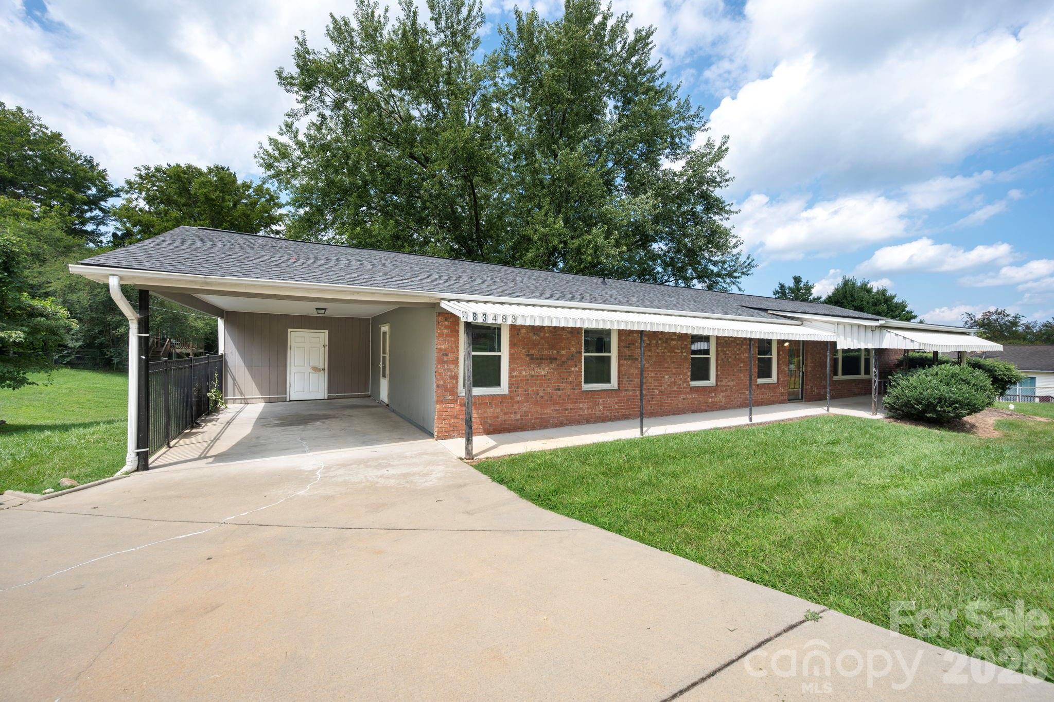 Carport with storage area. Entrance to home from carport goes into hallway with 3 bedrooms and 2 bathrooms. - 483 Caribou Road, Asheville