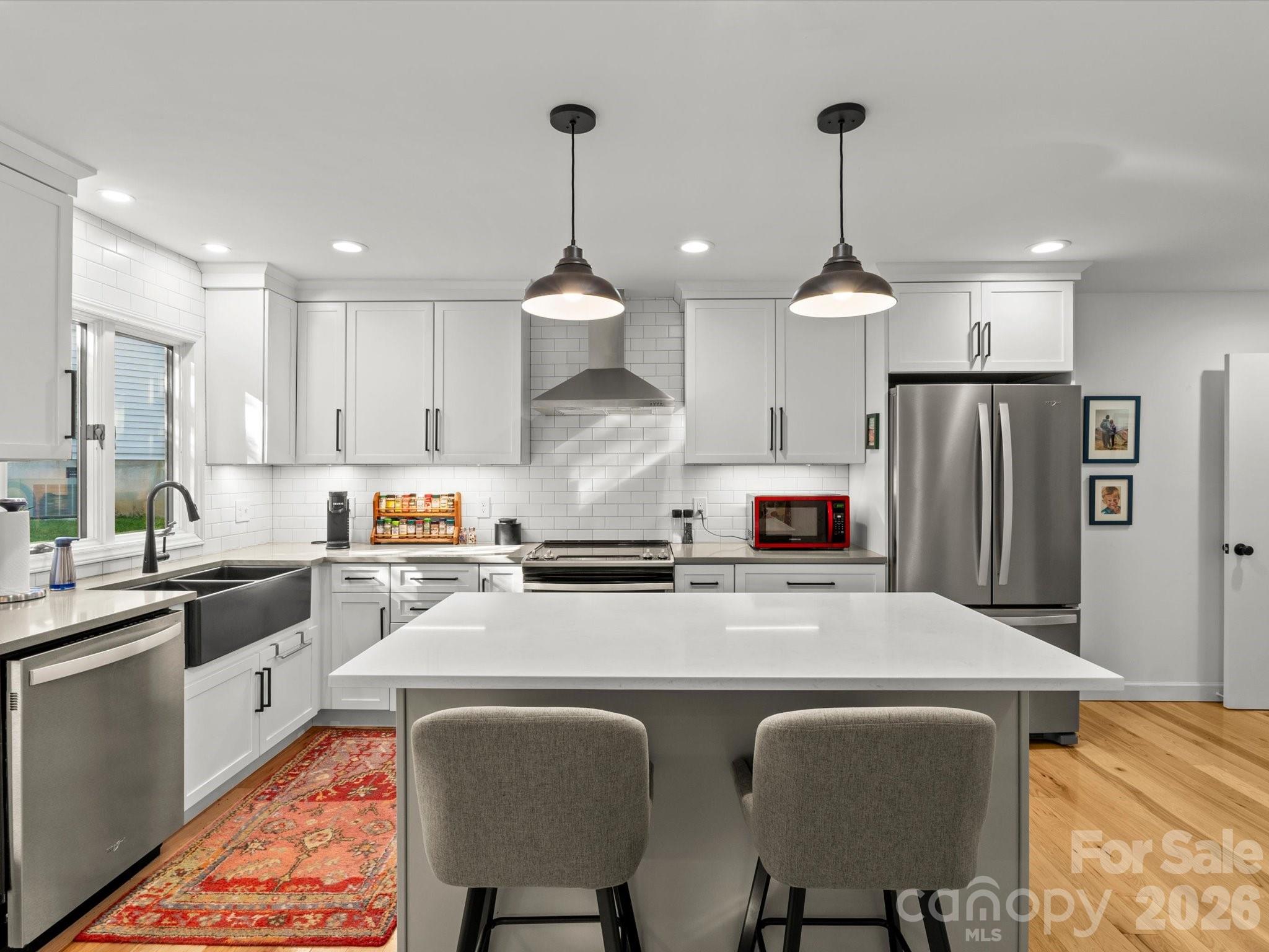A kitchen island and breakfast bar offer dining and entertaining options - 110 Aurora Drive, Asheville