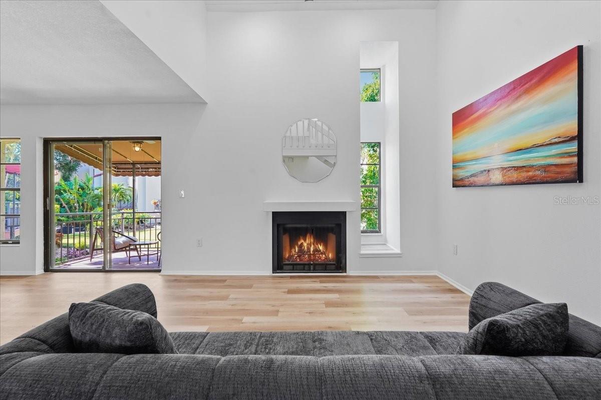 The main living space features a wood burning fireplace and convenient access to a large covered balcony off the main living area - 240 WINDWARD PSGE #702, CLEARWATER