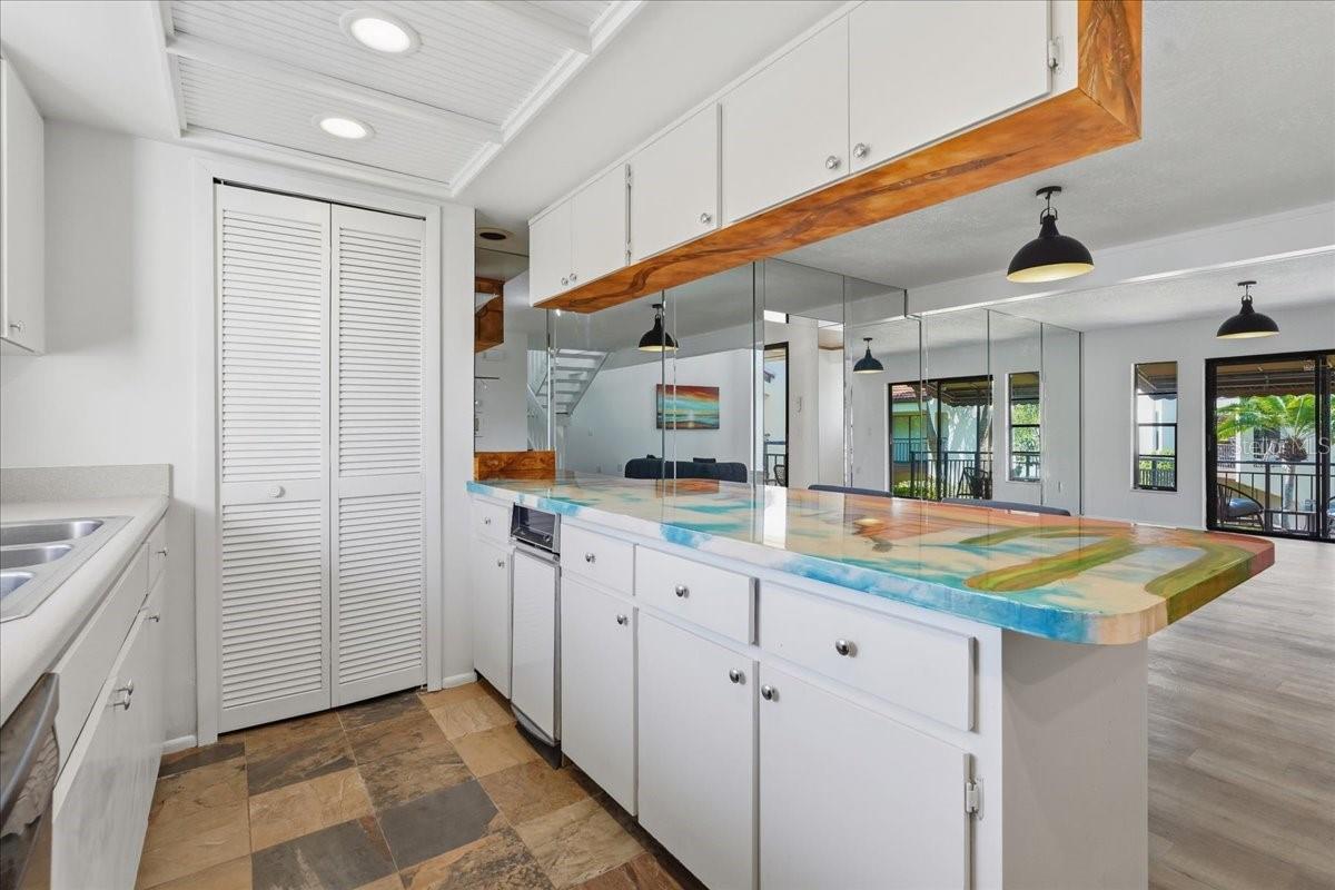 Seamless Social Flow: The open breakfast bar provides an unobstructed sightline directly into the main living and dining zones, including the expansive covered balcony porch, making entertaining a breeze - 240 WINDWARD PSGE #702, CLEARWATER