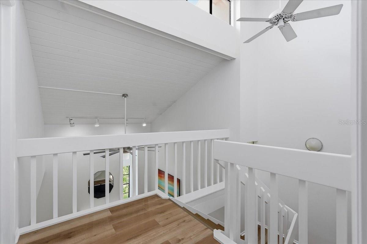 Ascend to the 2nd level, where the upper staircase opens to a dramatic overlook of the great room before leading to the private Double Primary Suites - 240 WINDWARD PSGE #702, CLEARWATER