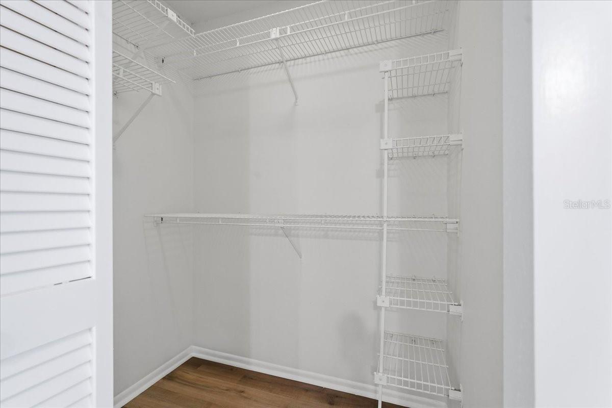 Primary Suite #1 boasts ample storage with dual closets, highlighted by a spacious walk-in design - 240 WINDWARD PSGE #702, CLEARWATER