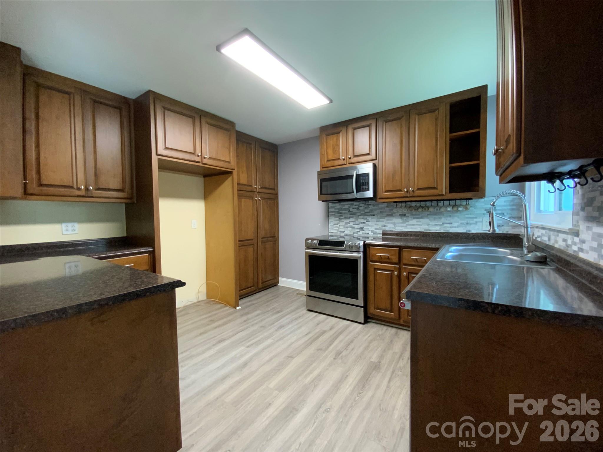 Kitchen includes dishwasher, microwave, electric range and magnetic safety locks on the bottom cabinet doors - 325 Glenwood Drive, Mooresville