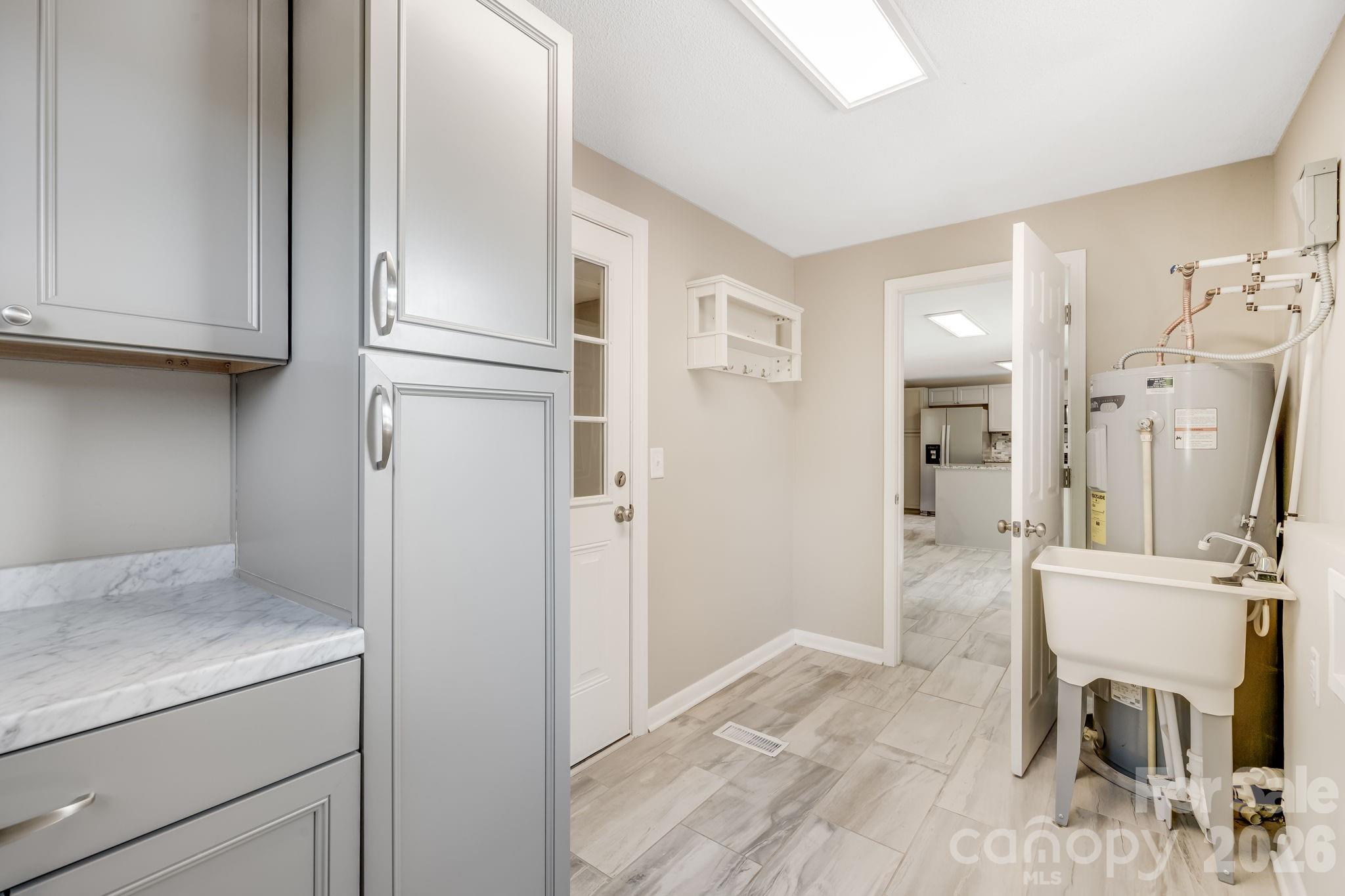 Laundry room with a sink and lots of cabinet space! - 409 Oak Street Extension, Forest City