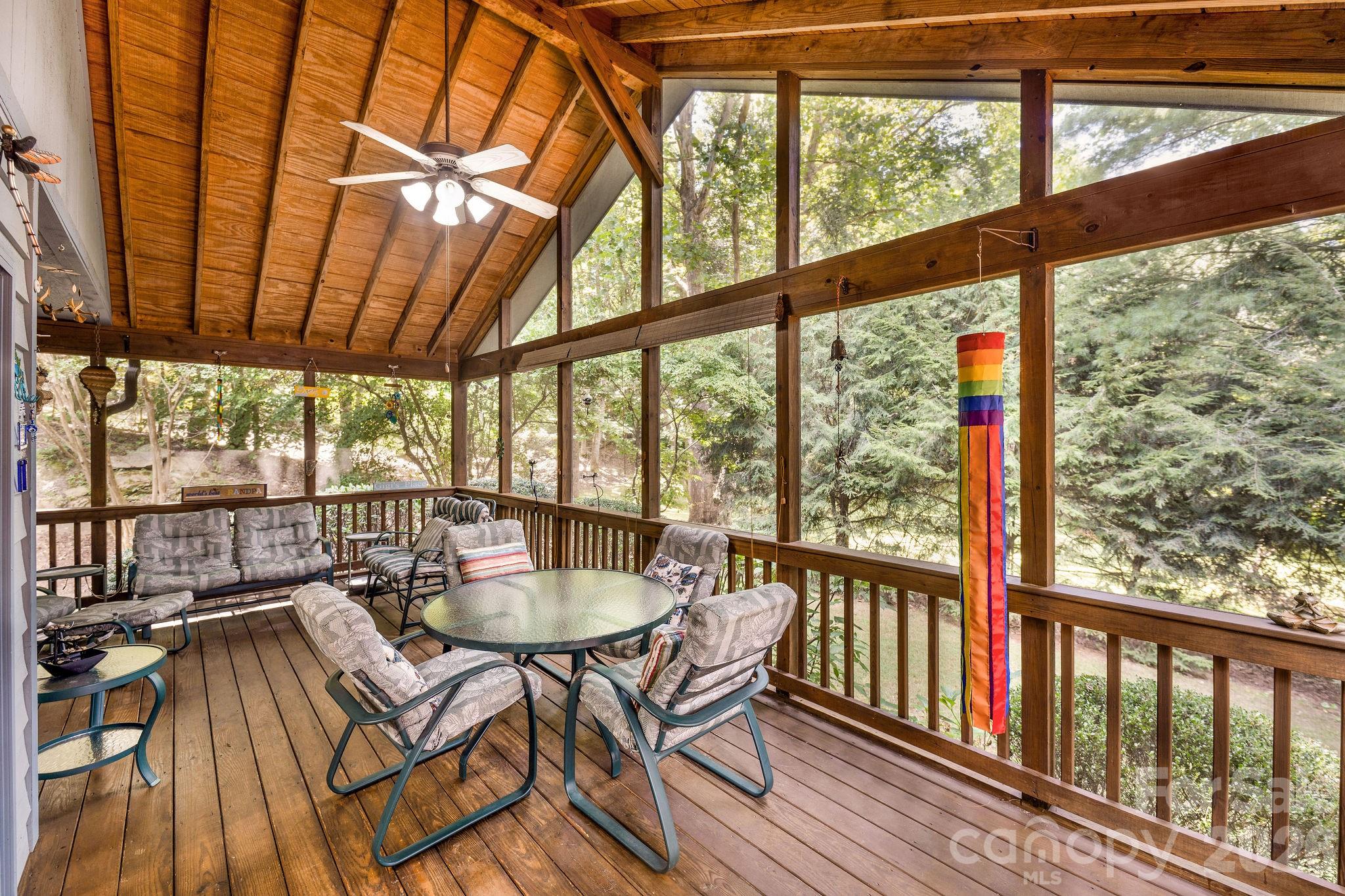 The screen porch has vaulted ceilings and access from the kitchen and the primary bedroom. The backyard is a park like setting. - 31 Hillcreek Drive, Asheville