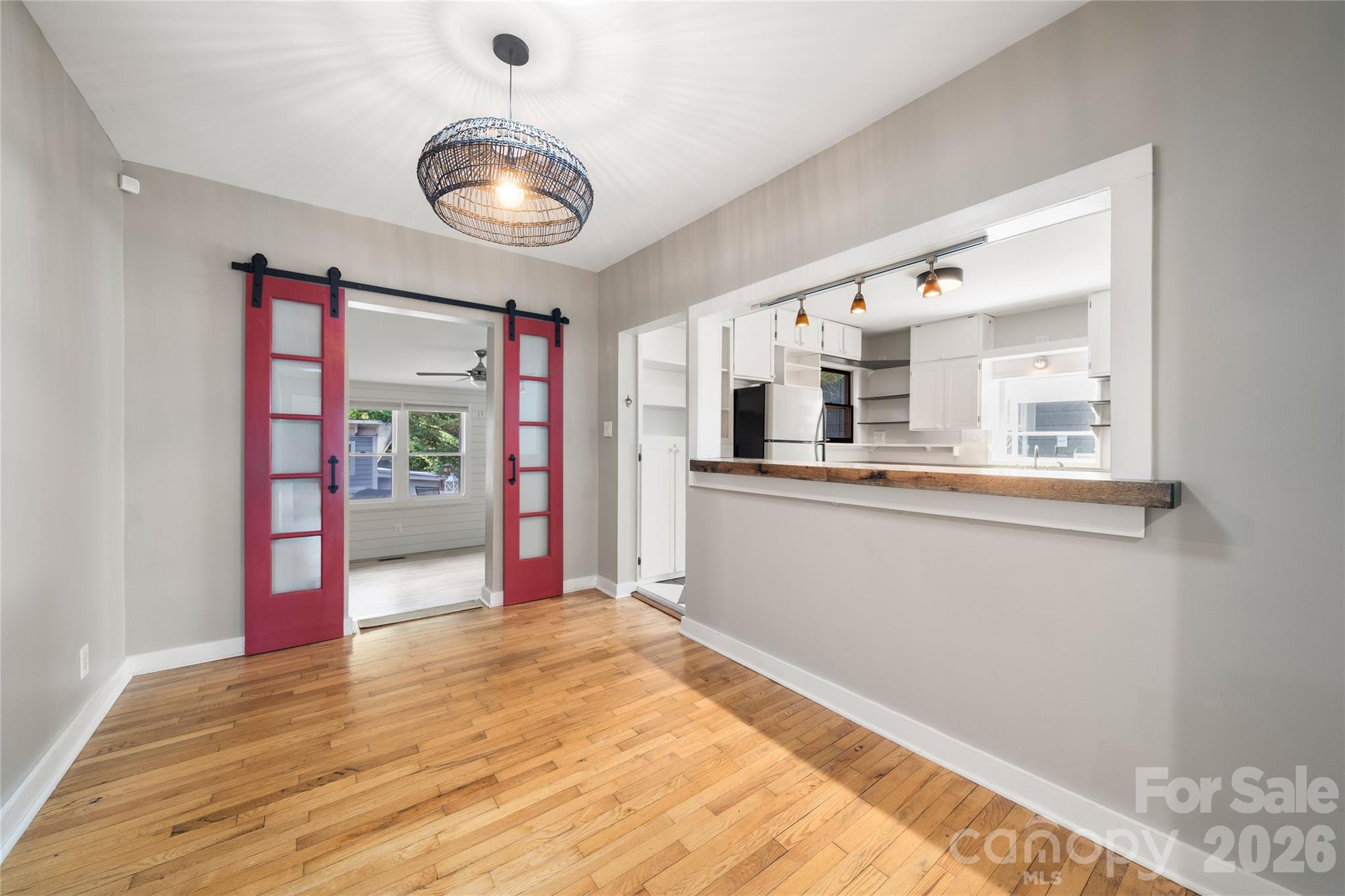 Thoughtfully curated dining room area with wood breakfast bar and barn doors separating the recreation/flex room - 101 Olney Road, Asheville