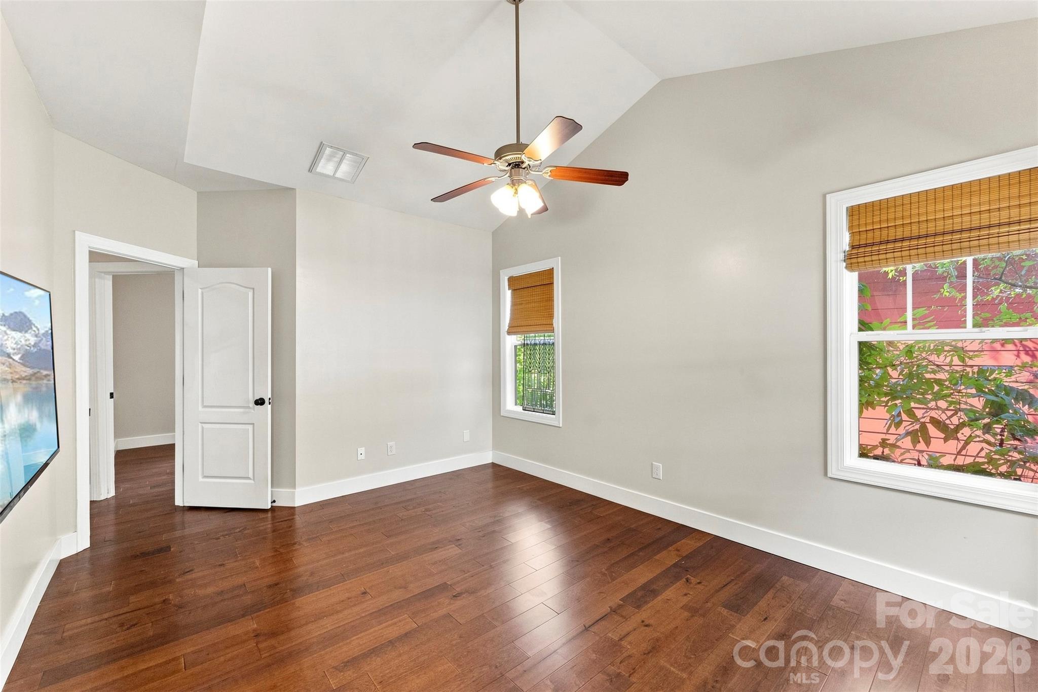 Primary bedroom with hardwood flooring and vaulted ceilings - 14100 Garden District Row, Huntersville