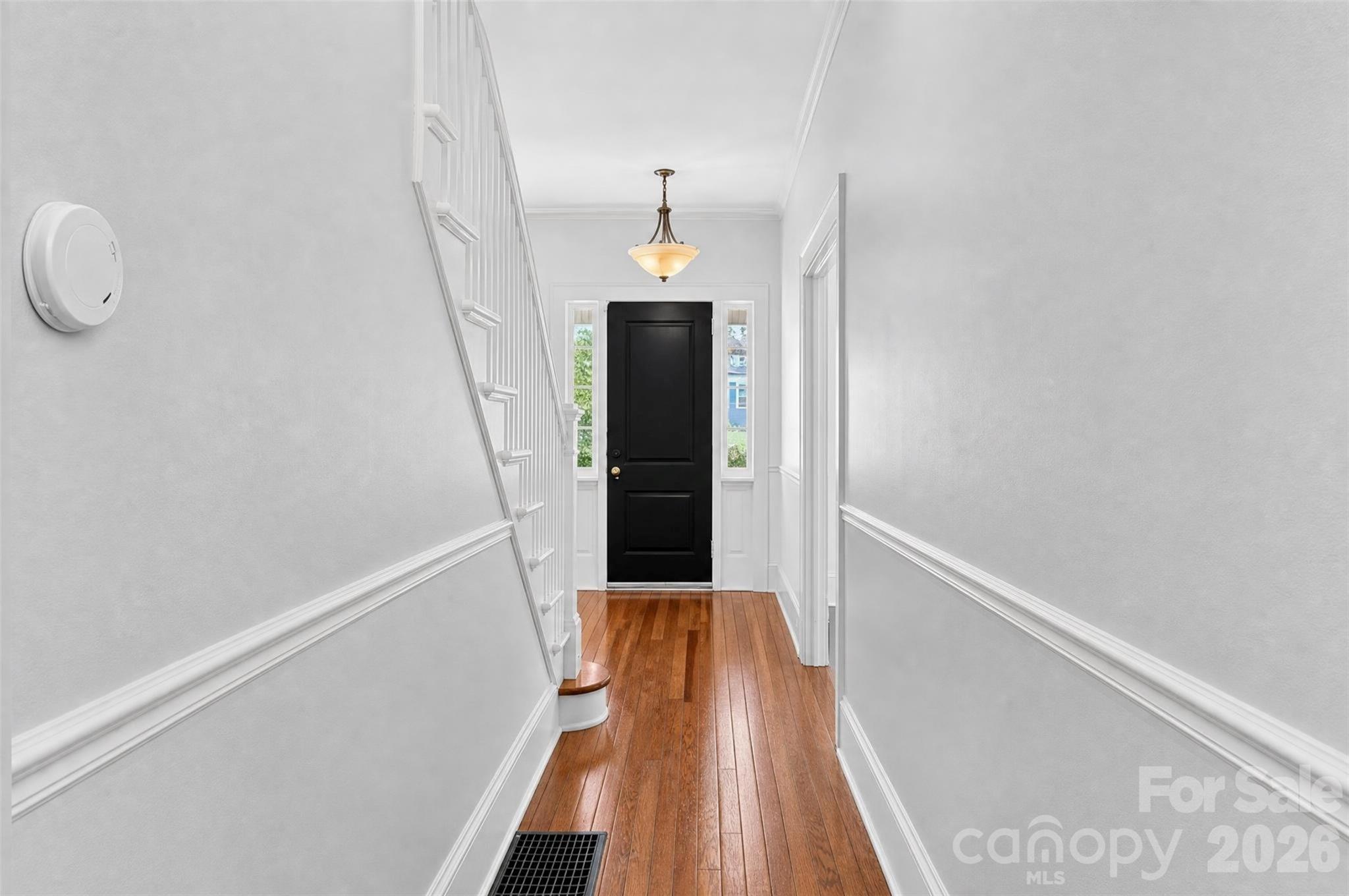 Another view of the welcoming foyer highlights the hardwood floors, detailed millwork, and natural light from the front entry. - 638 Carolina Avenue, Gastonia