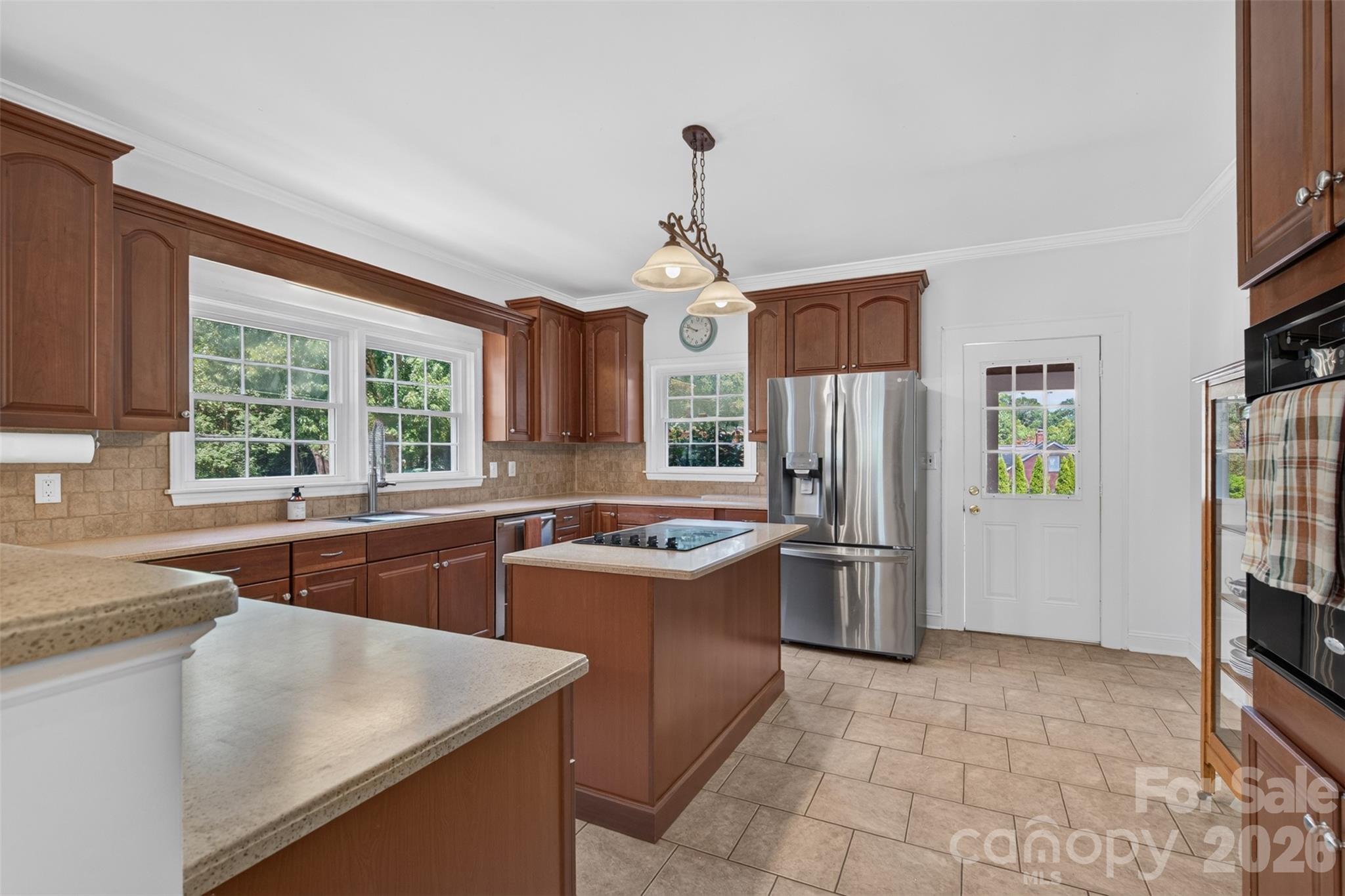 Spacious kitchen with generous cabinetry and counter space, a center-island cooktop, wall oven, and stainless steel appliances. Refrigerator included. - 638 Carolina Avenue, Gastonia