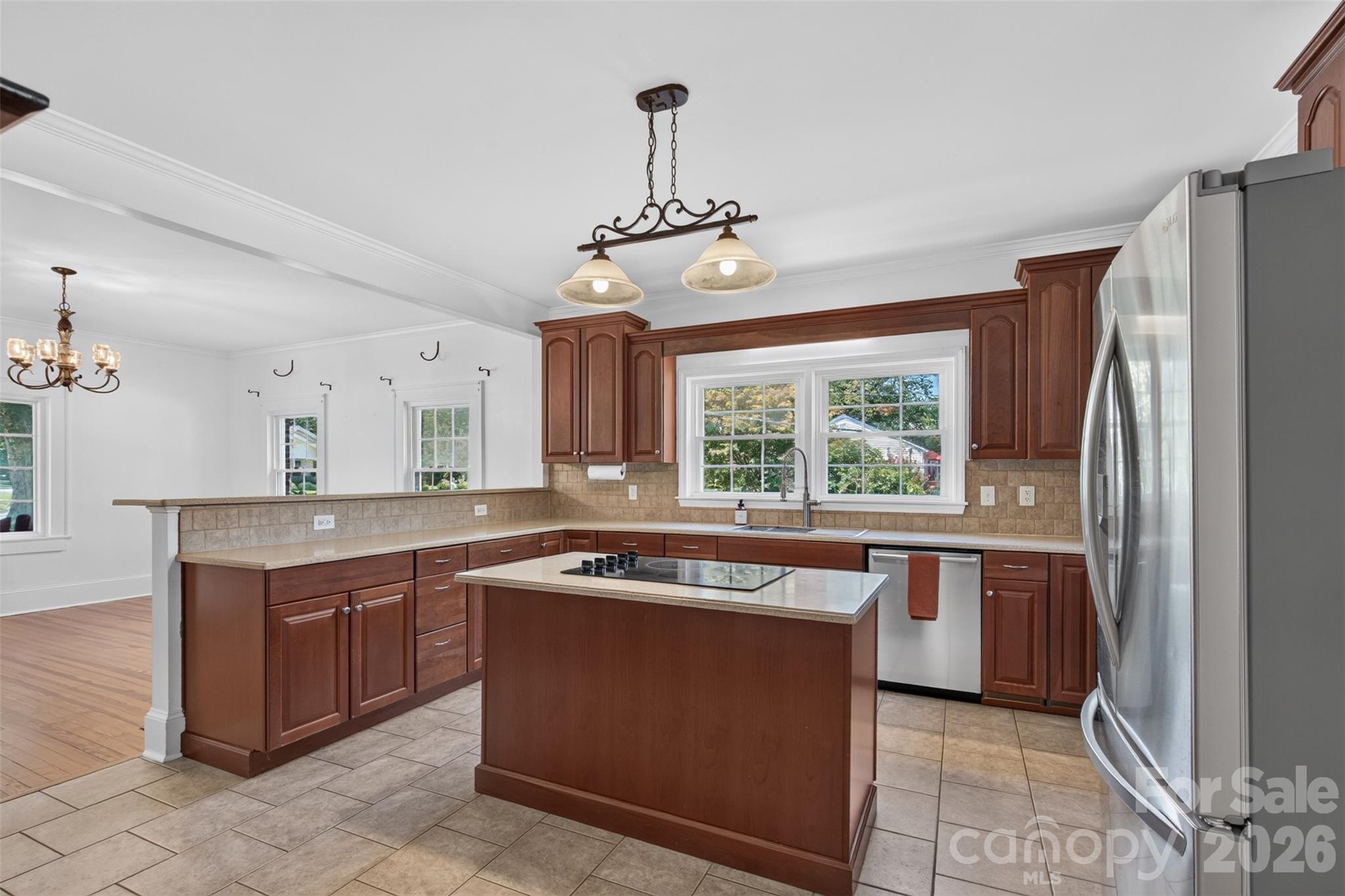 A wide window above the kitchen sink brings in natural light and provides a view of the outdoor surroundings. Pendant lighting adds another layer of character to the space. - 638 Carolina Avenue, Gastonia