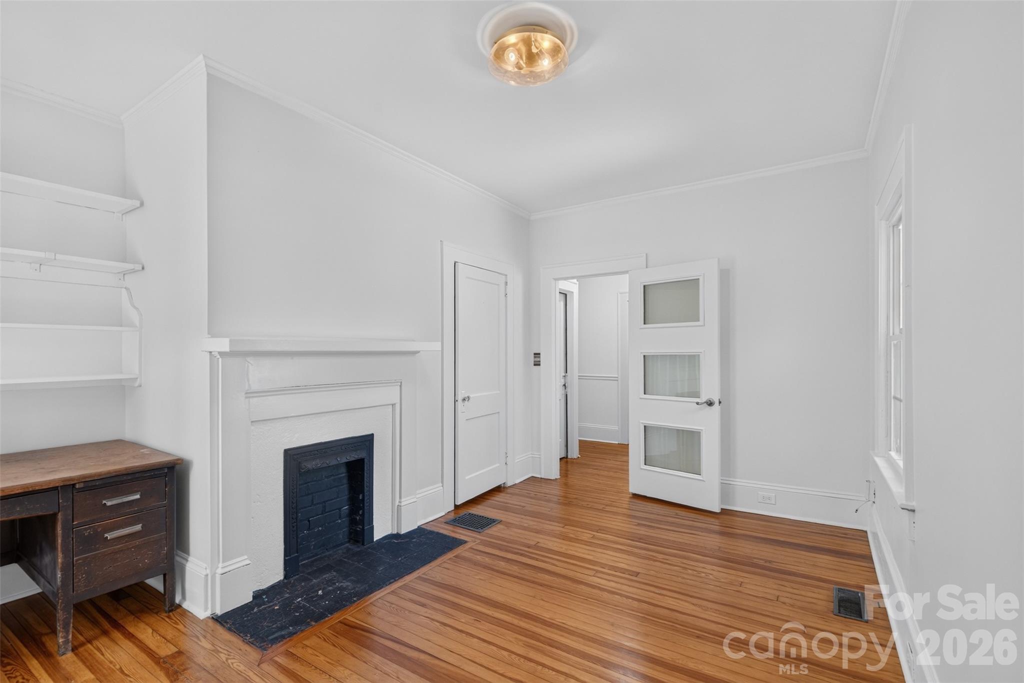 Flexible main level room with hardwood floors, built-in shelving and a decorative fireplace is well suite for use as a bedroom, office, or bonus space. - 638 Carolina Avenue, Gastonia
