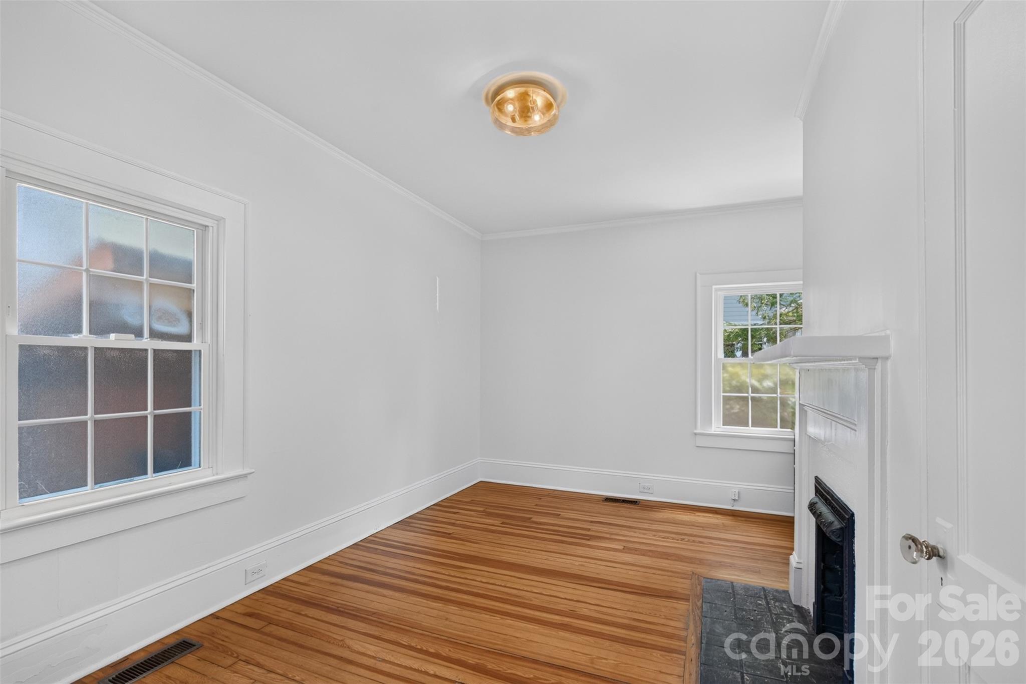 An alternate view of this flexible main level room shows its hardwood floors, natural light, and generous wall space for a variety of uses. - 638 Carolina Avenue, Gastonia
